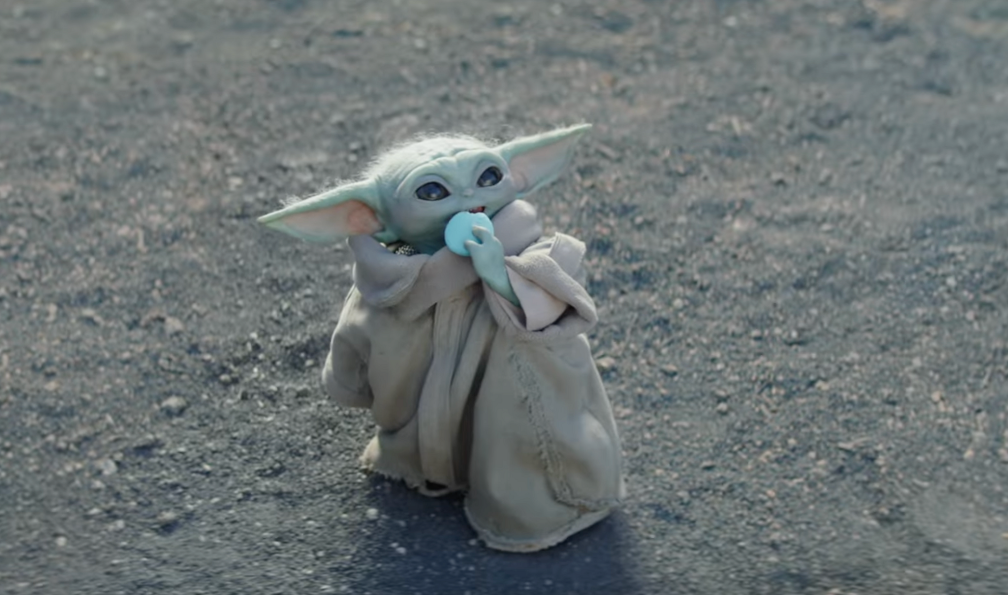 Baby Yoda eating a Macaroon.