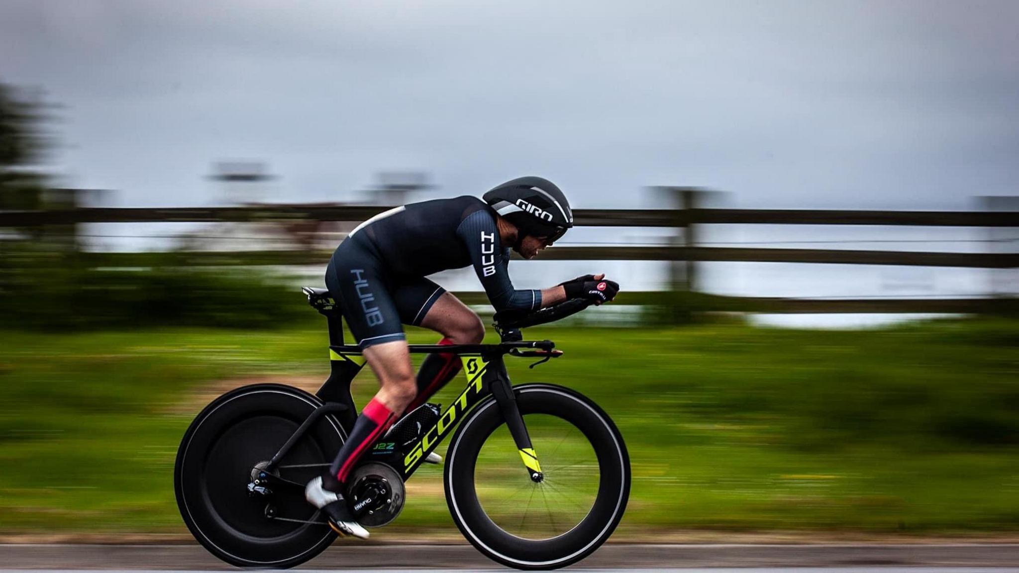 Carl Donaldson on a time trail bike with tri bars and clearly travelling at speed 