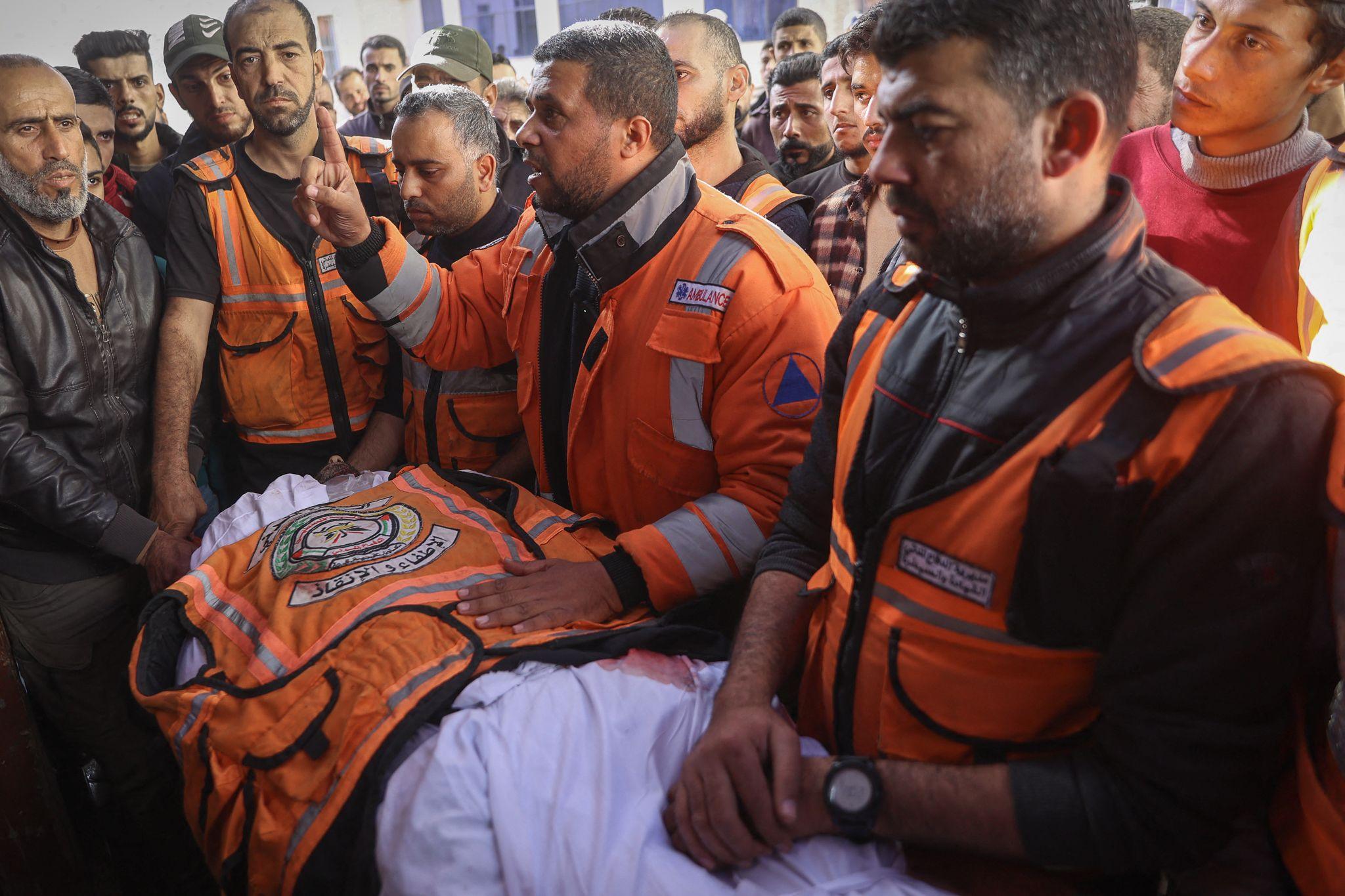 Members of the Gaza Civil Defence attend the funeral of a colleague who was killed alongside his son in an Israeli strike in Gaza City.