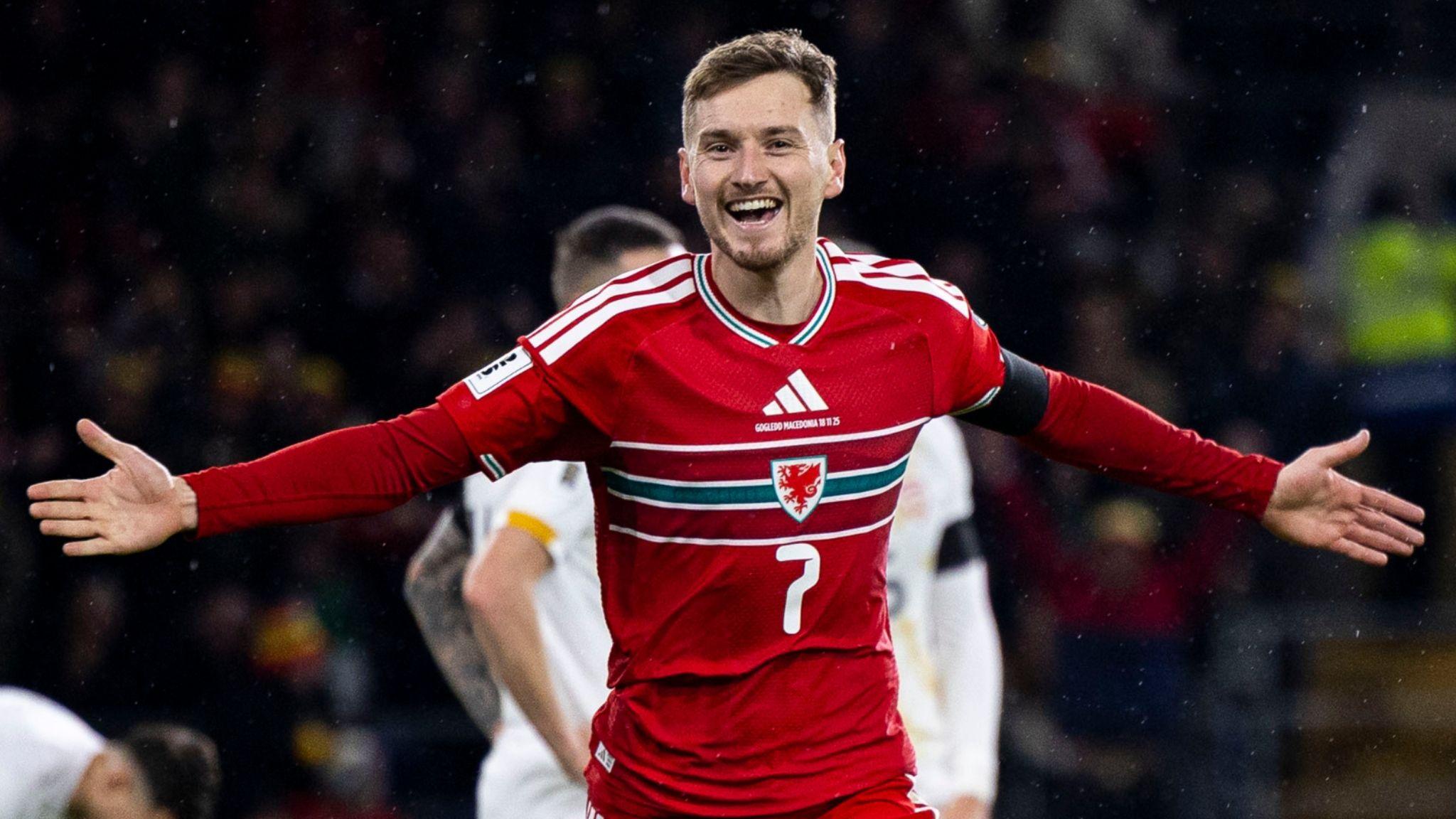 David Brooks spreads his arms wide and beams in celebration at scoring against North Macedonia