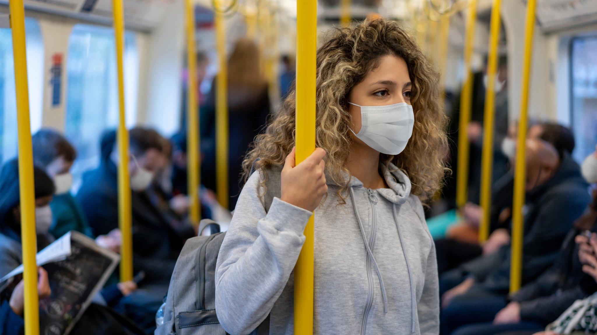 Woman on a train in a mask