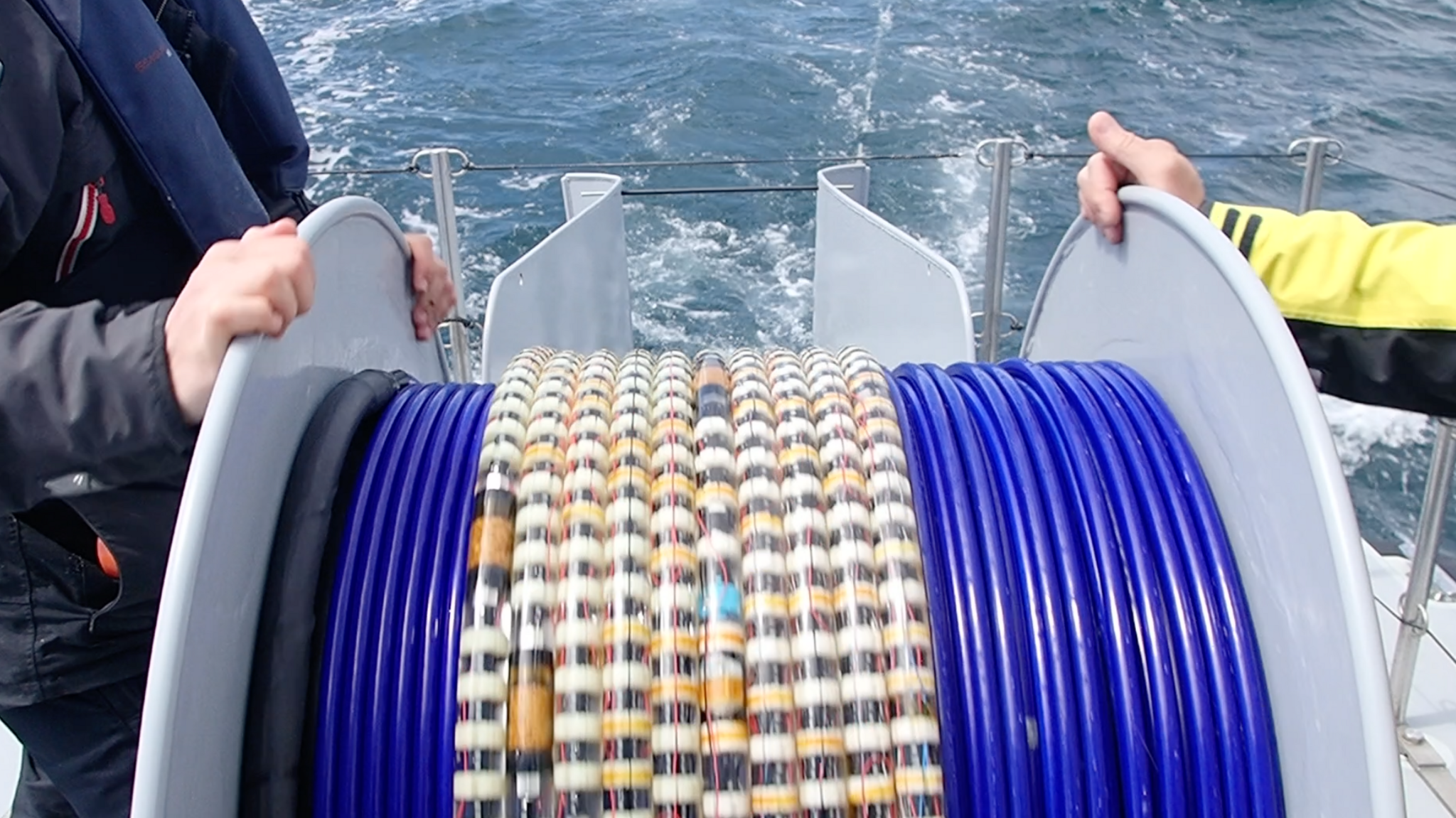 A drum holding fibre optic cable, mounted on the bow of a ship.