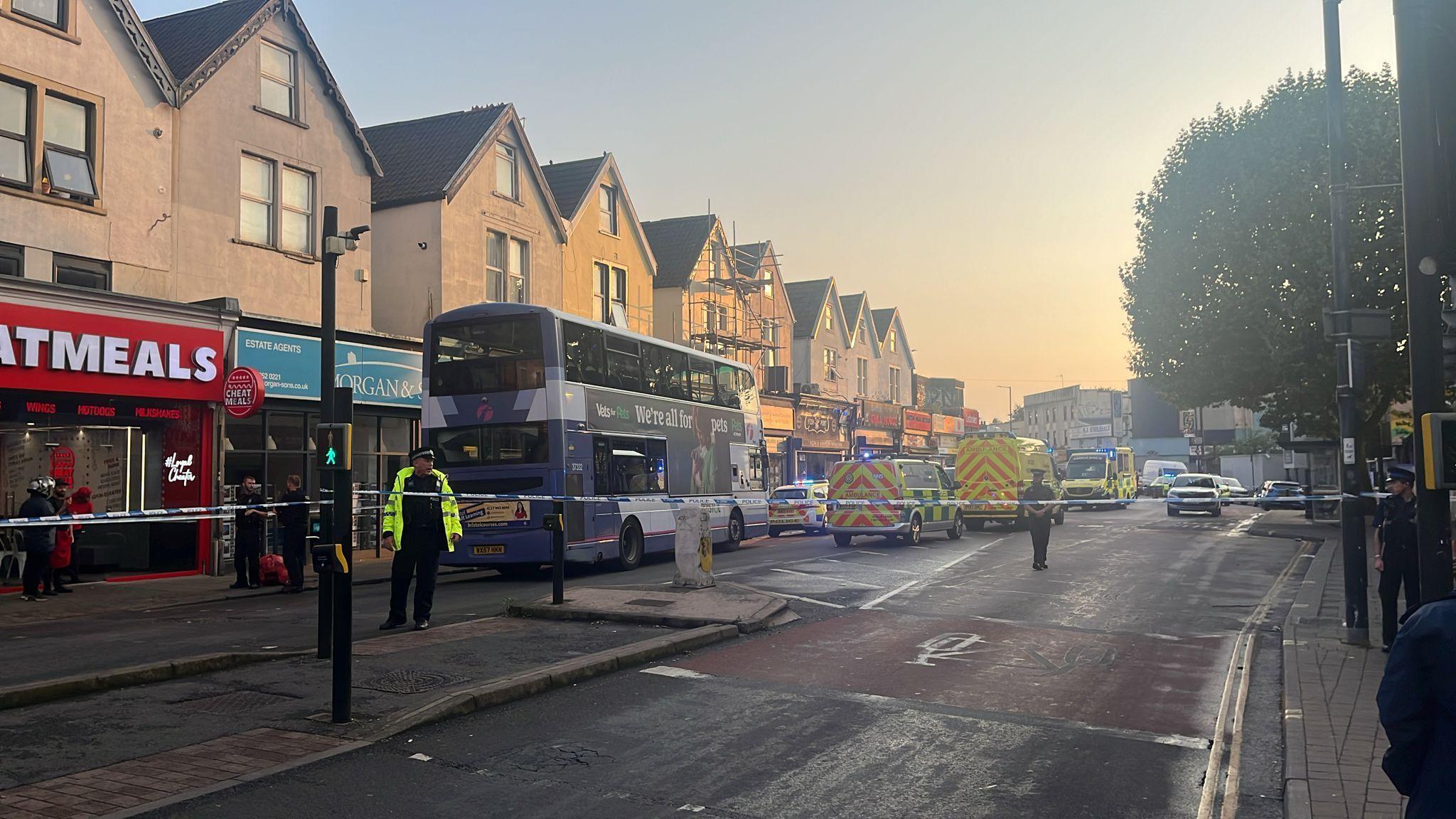 A road closure on Stapleton Road in Bristol with police tape, police officers and an ambulance