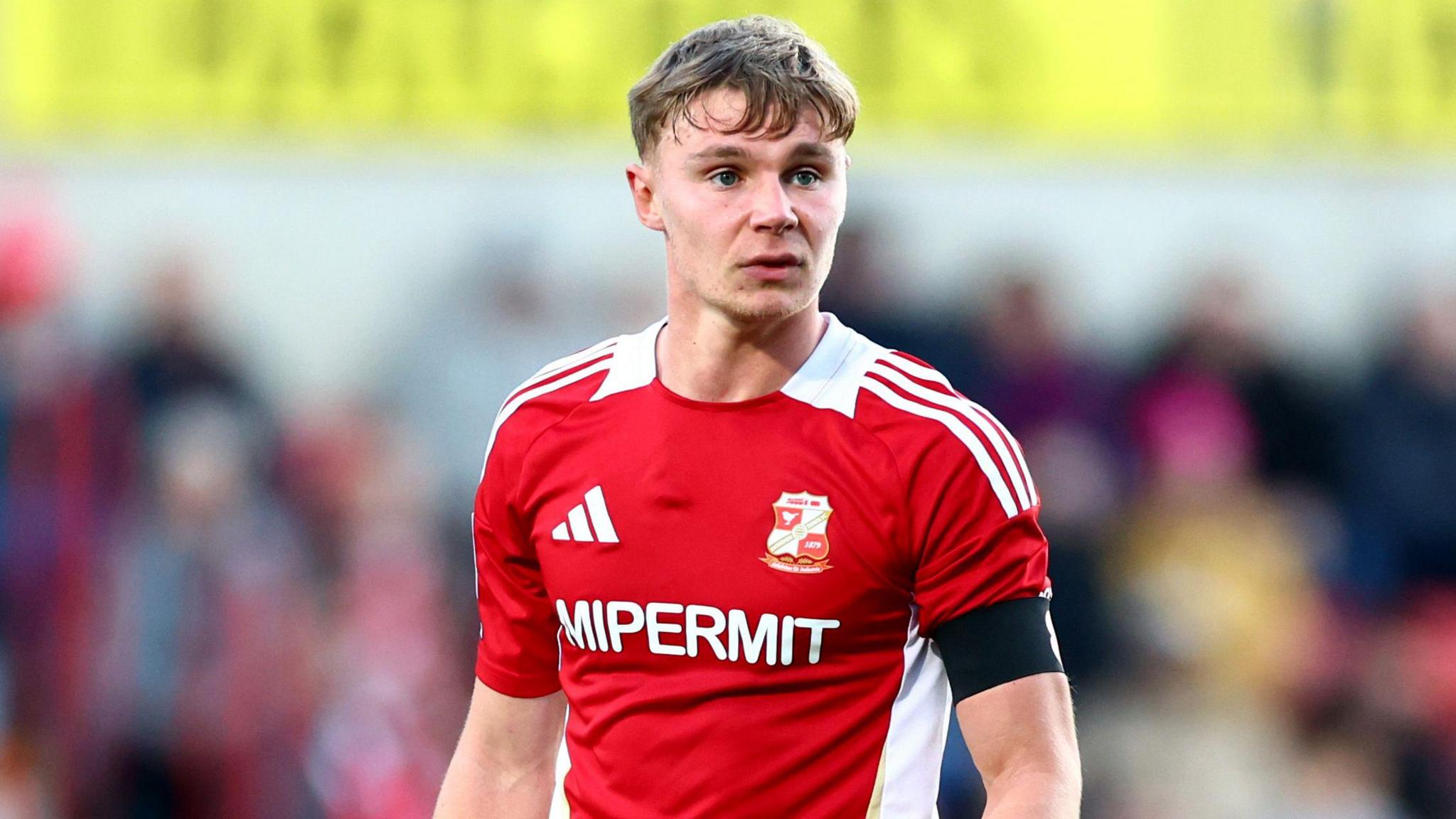 Paul Glatzel standing on the pitch with his arms by his sides during a match for Swindon