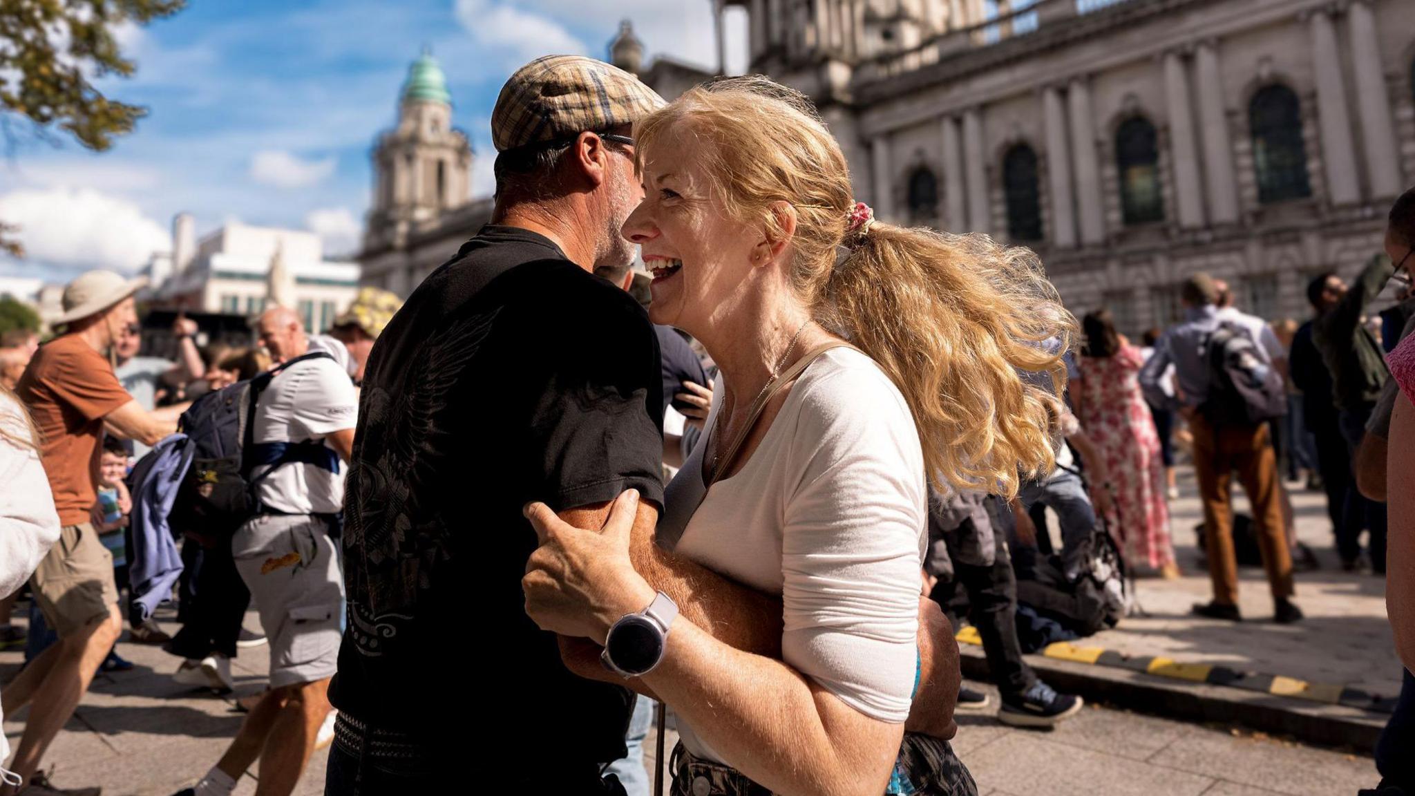 A man and a woman dancing outside Belfast City Hall