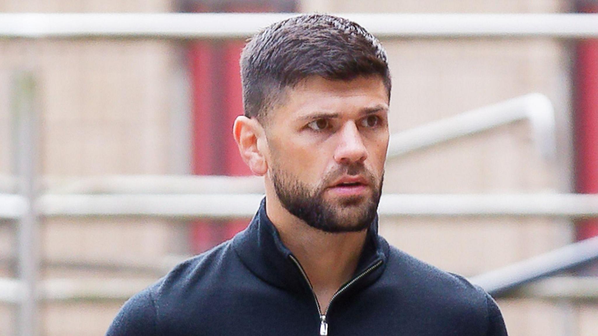 Joe Cordina, a man with brown hair and a brown beard. He's wearing a navy quarter-zip. 