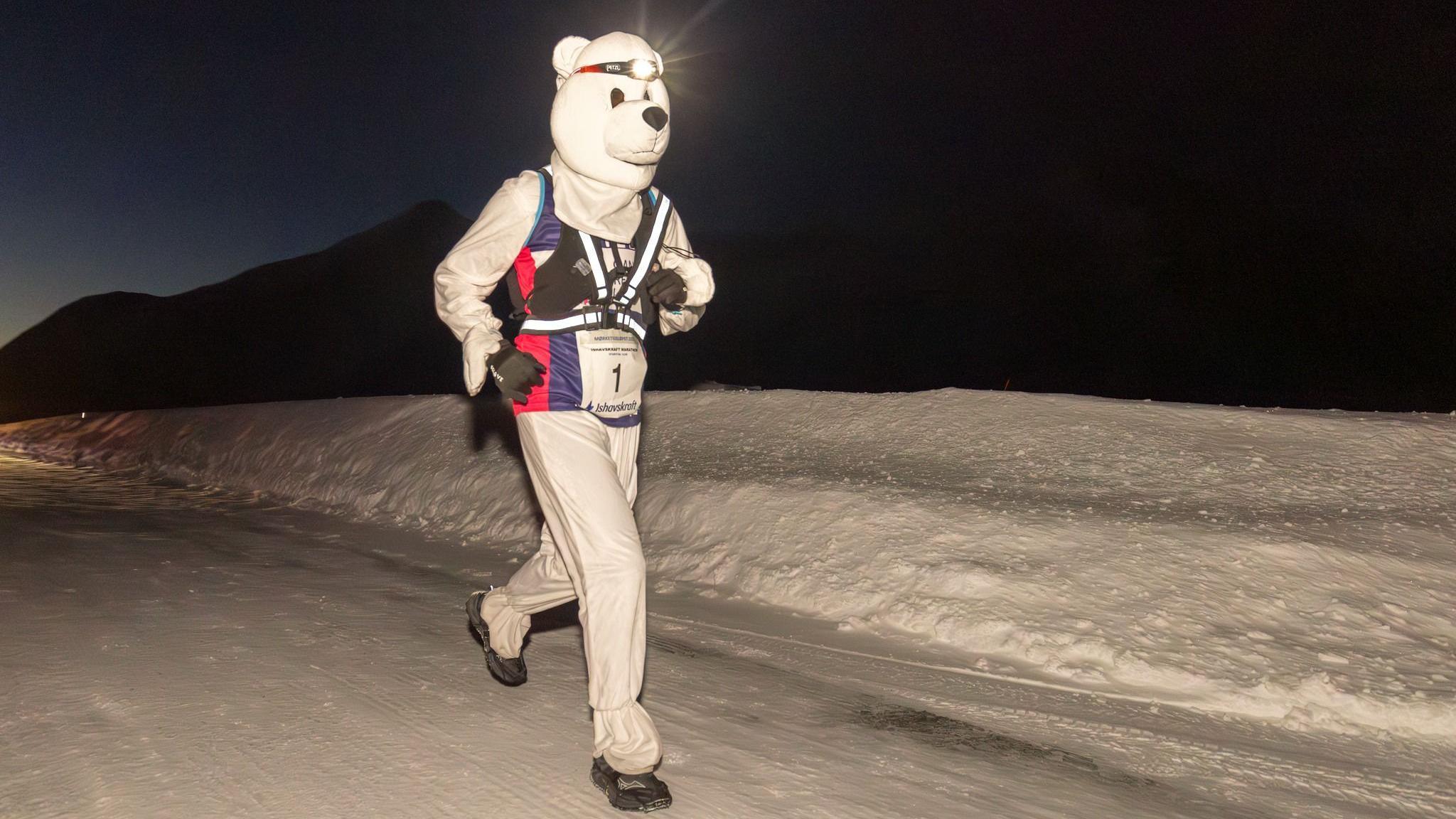 A woman dressed as a polar bear running in the dark on ice near Tromso, Norway. 