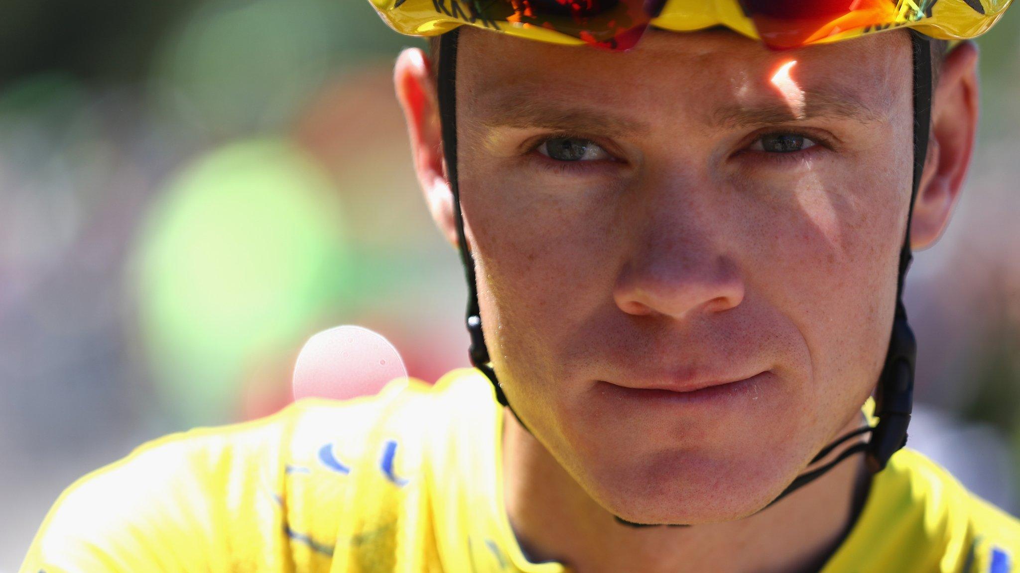 Chris Froome looks on while wearing the Tour de France leader's yellow jersey