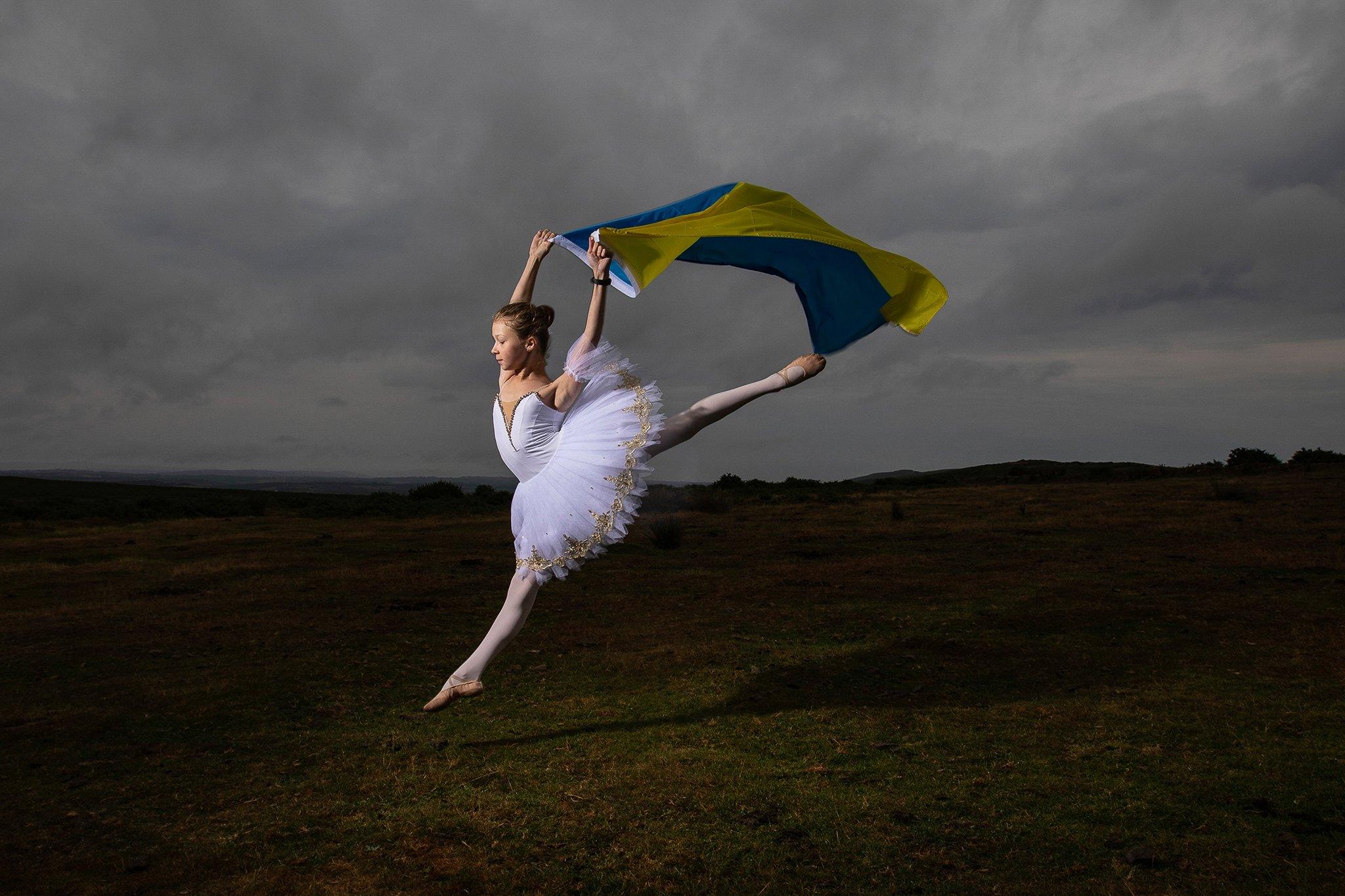 Accompanied with the Ukrainian flag, award-winning, young ballerina, Kateryna Andrushyna, 12, proudly demonstrates her skills for Ukraine Independence Day. Kateryna and her family are refugees from Boryspil, a city near Kyiv, that was bombed on the first day of the Russian Invasion,