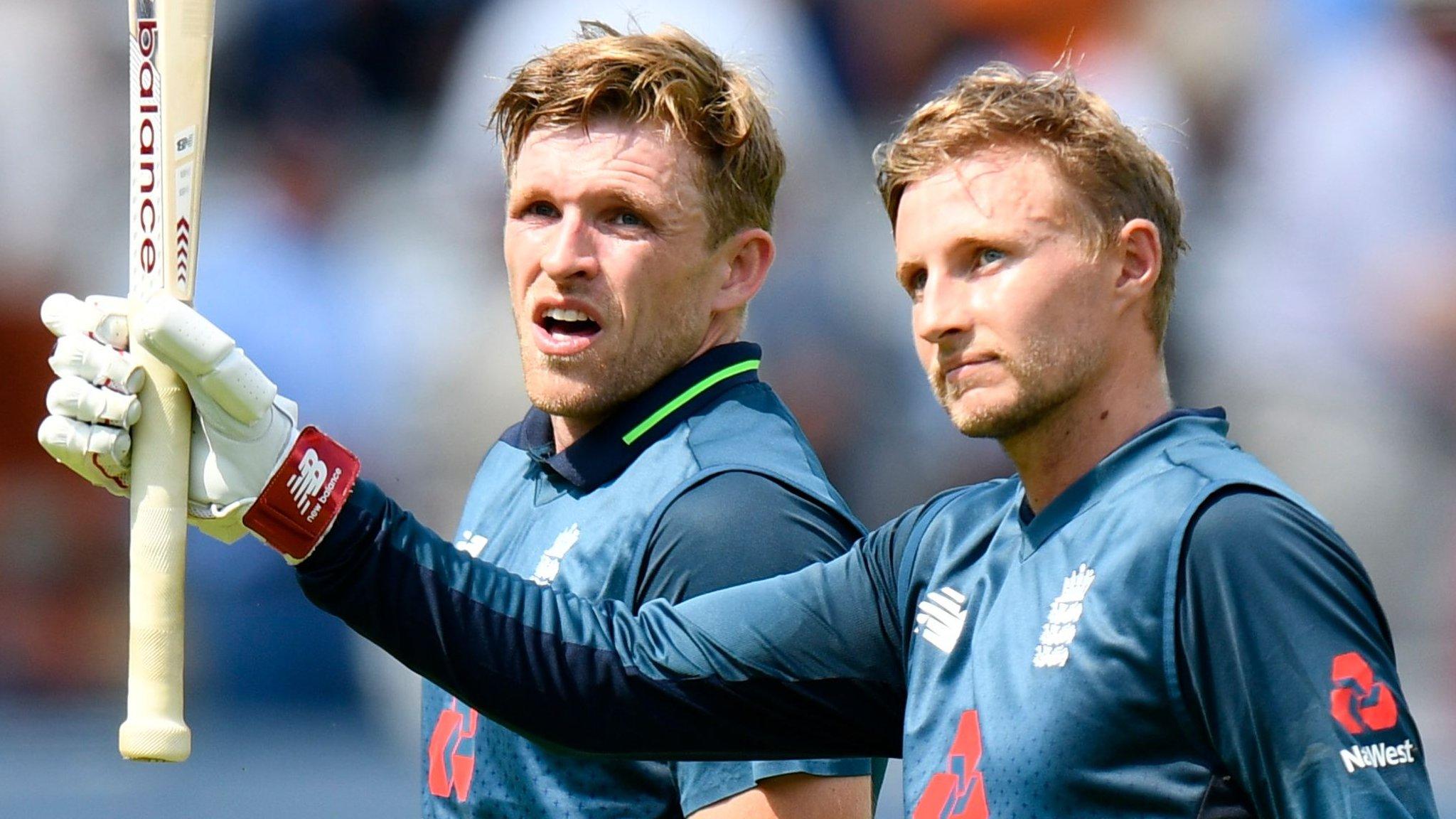 Joe Root raises his bat while walking off after scoring a century