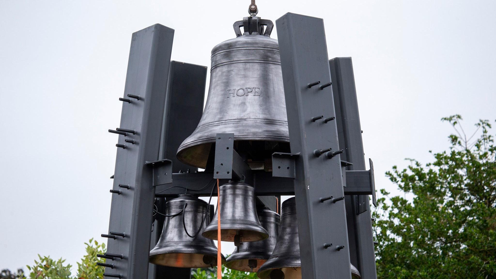 A big bell with HOPE cast on it held up by four steel supports