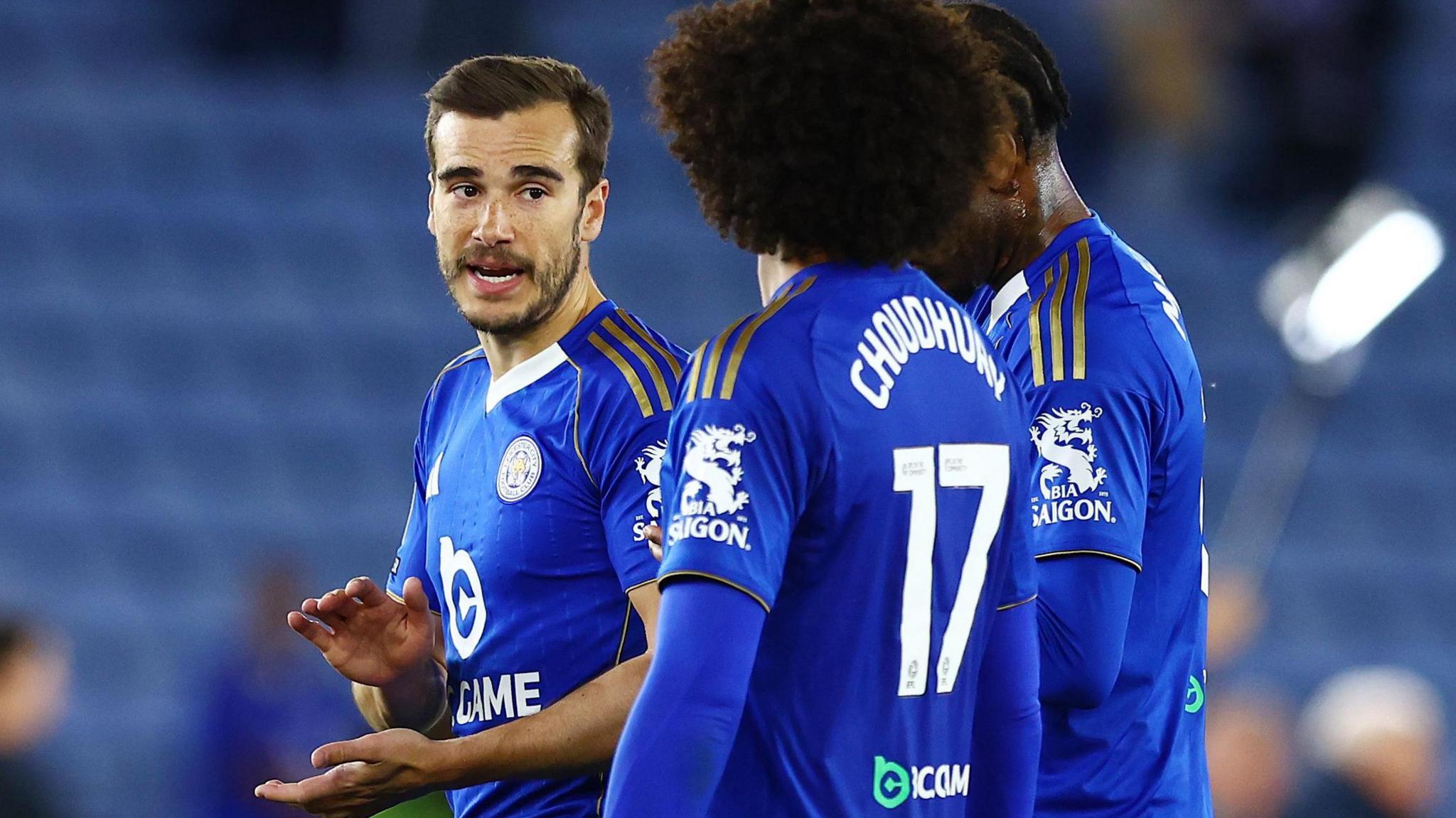 Harry Winks (left) speaking to Leicester City team-mate Hamza Choudhury on the pitch