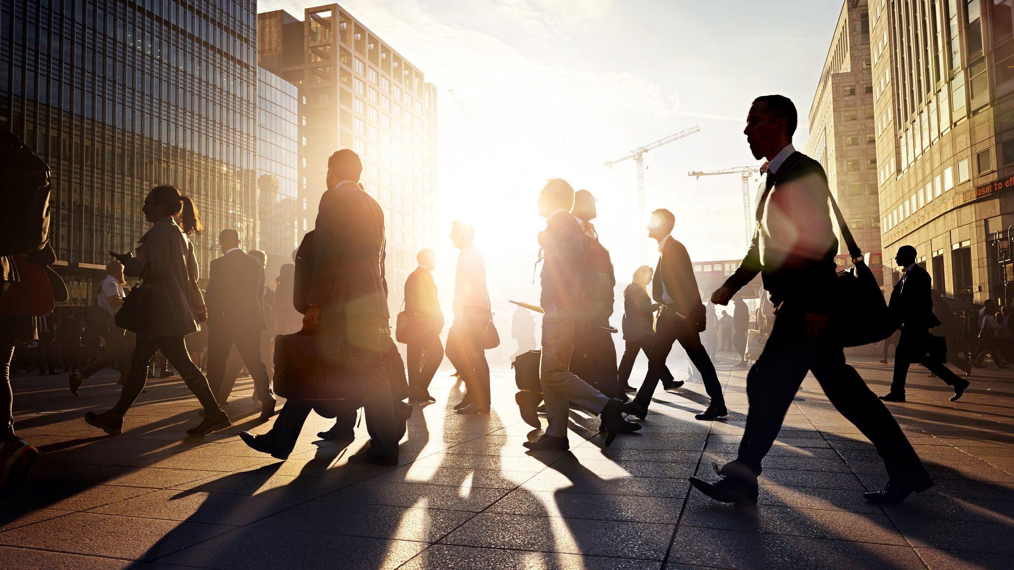 Employees walking to work in the city at sunrise