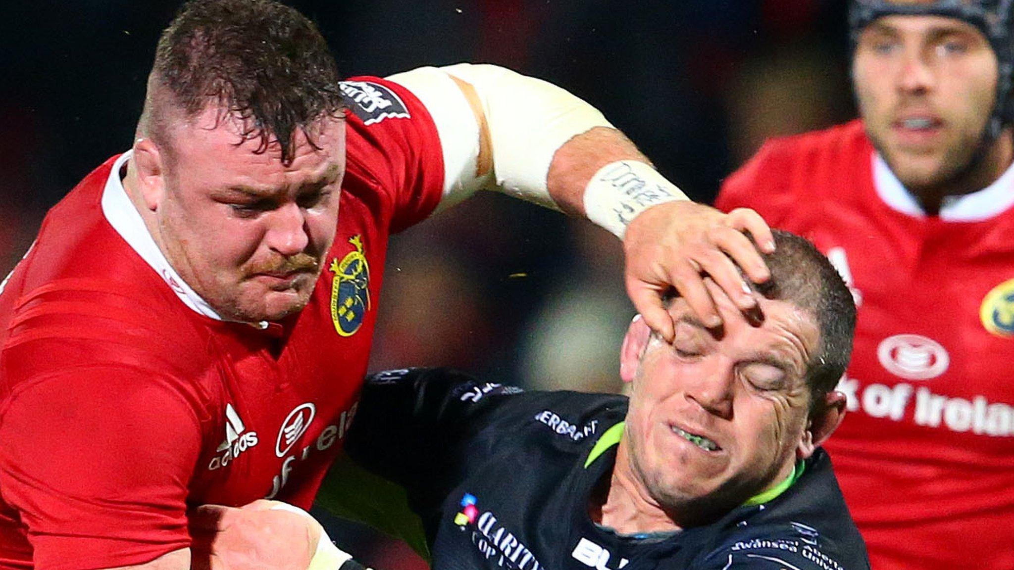 Munster's Dave Kilcoyne is tackled by Paul James of Ospreys