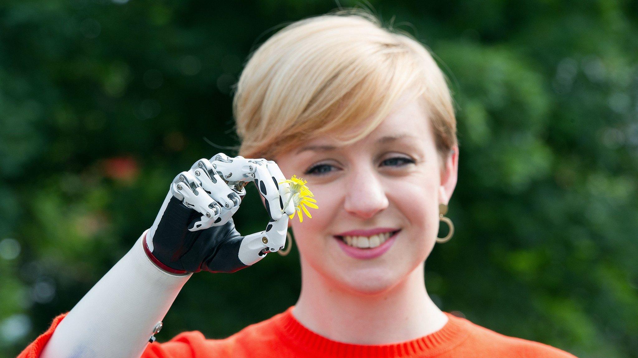 Nicky Ashwell with her bionic hand holding a flower