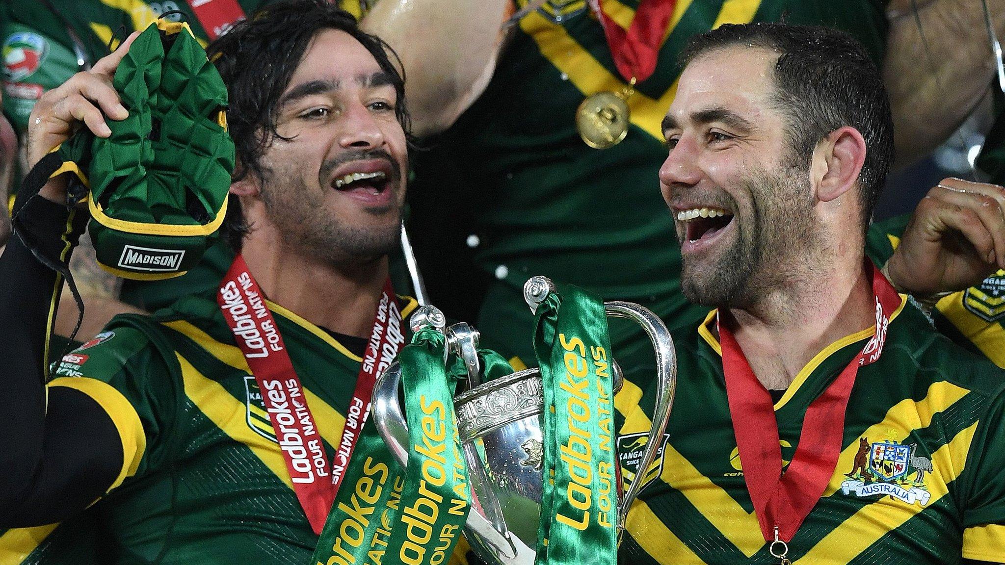 Cameron Smith (R) holds the trophy as he celebrates with Australia"s stand-off Johnathan Thurston