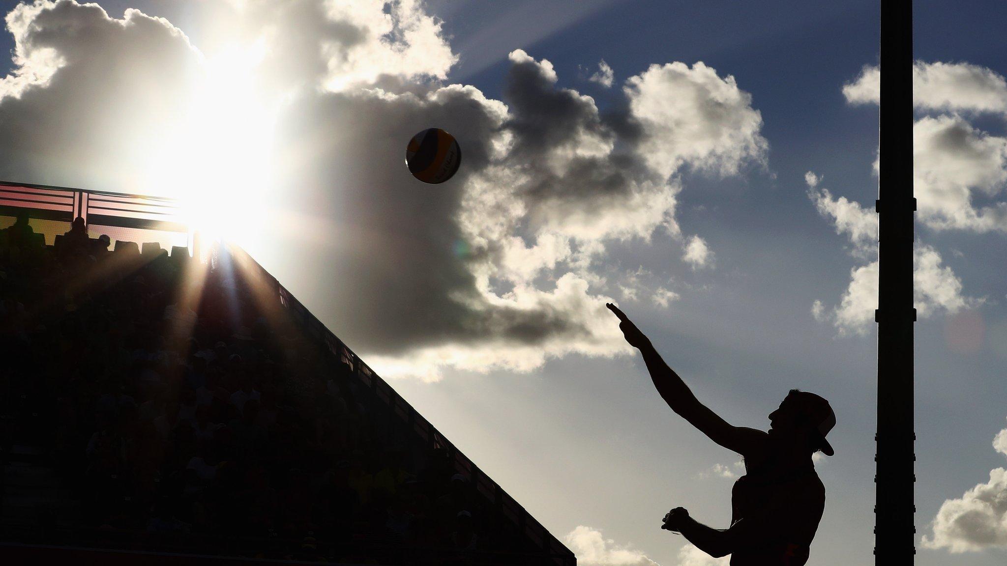 Chris Gregory of England serves against Dimitris Apostolou and Georgios Chrysostomou of Cyprus during the men's beach volleyball preliminary round