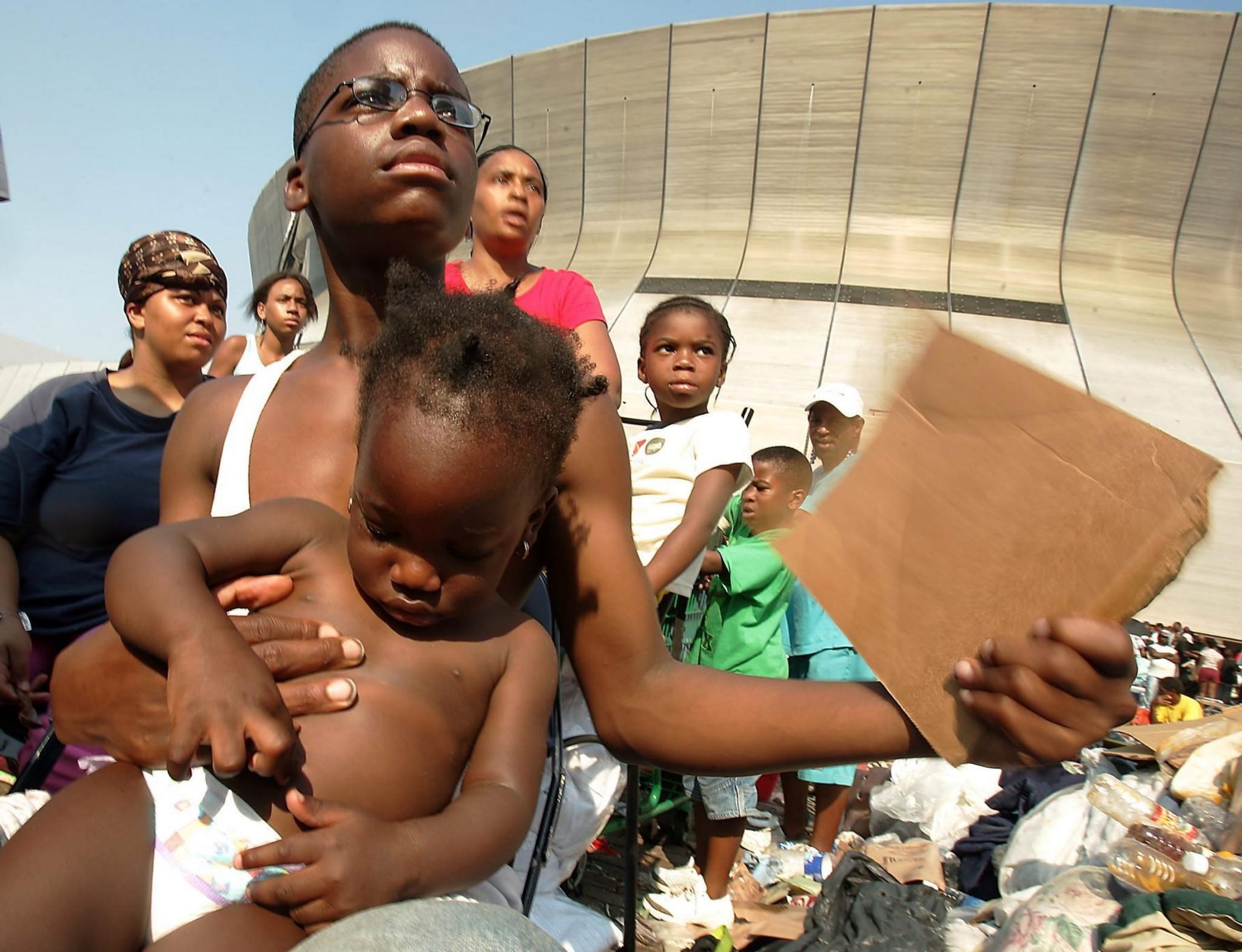 A young boy holds a smaller child outside the New Orleans Superdome