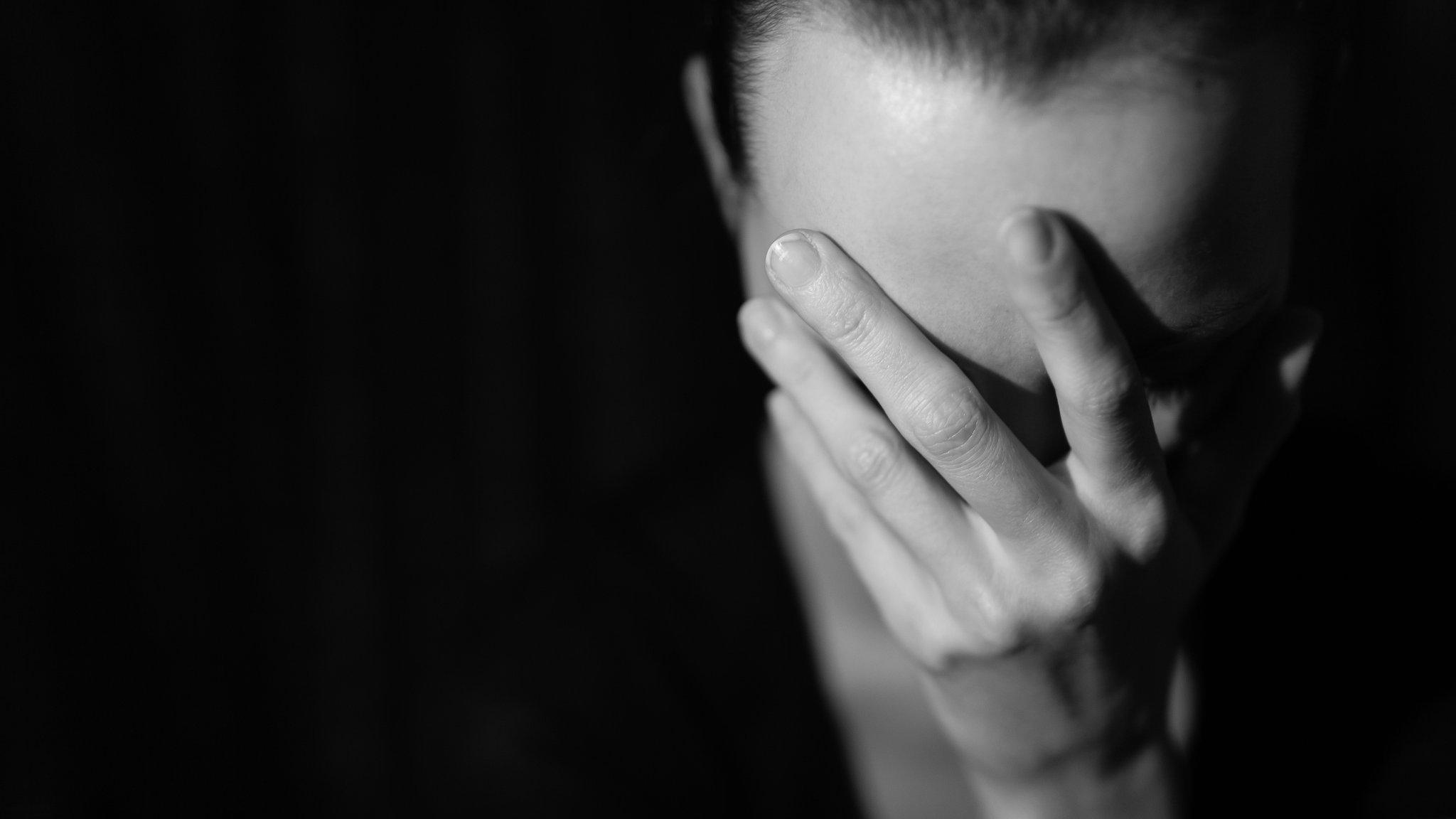 Woman holding head in her hand - posed - black and white image