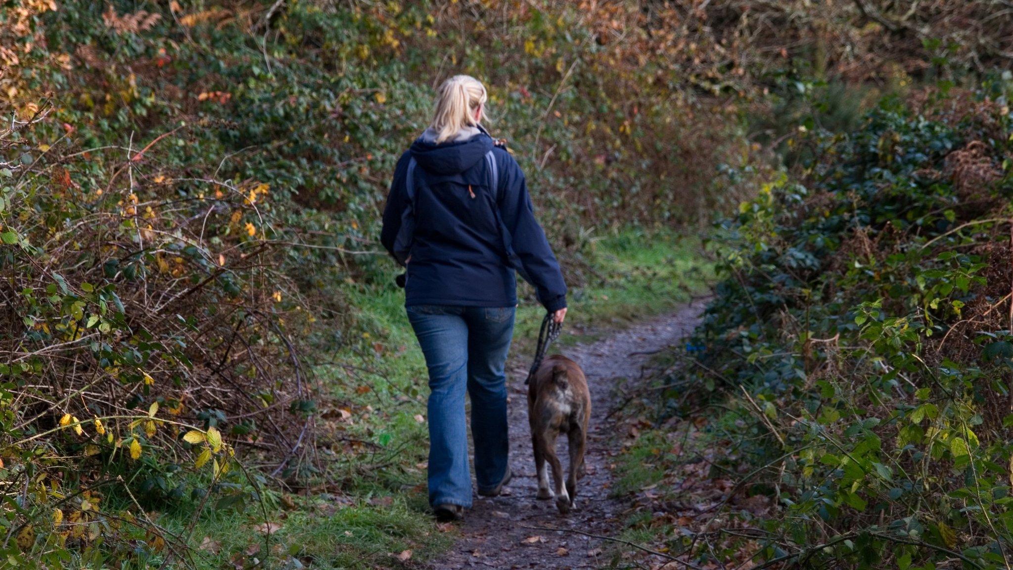 Woman walking a dog on a lead