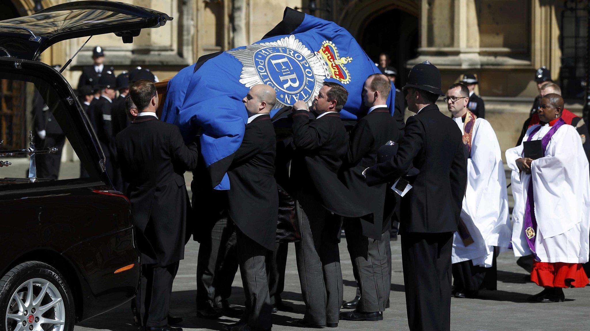 PC Palmer's coffin is carried from the hearse into Westminster