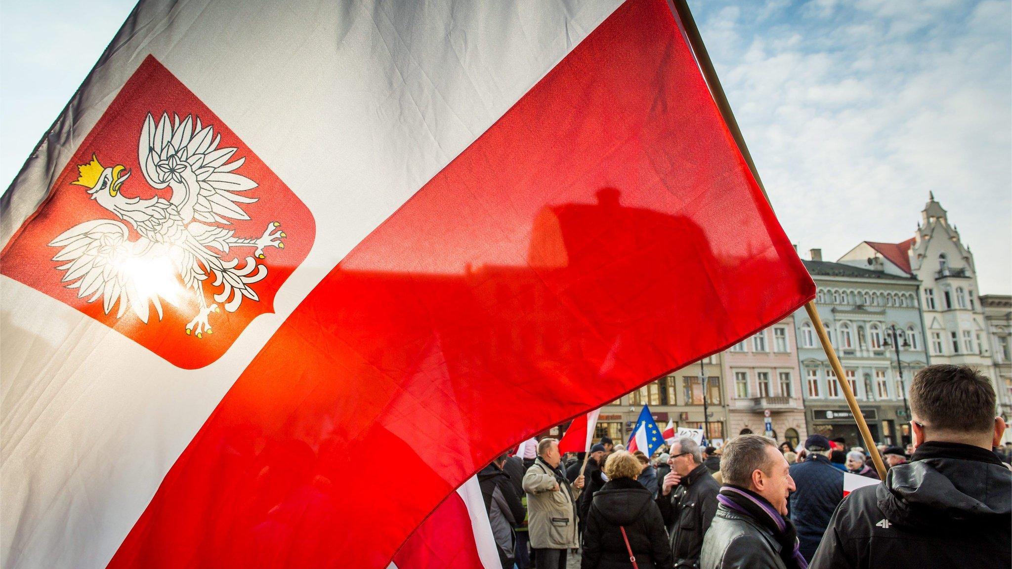 People wave flags during a demonstration at the Old Market in Bydgoszcz, 19 December 2015.