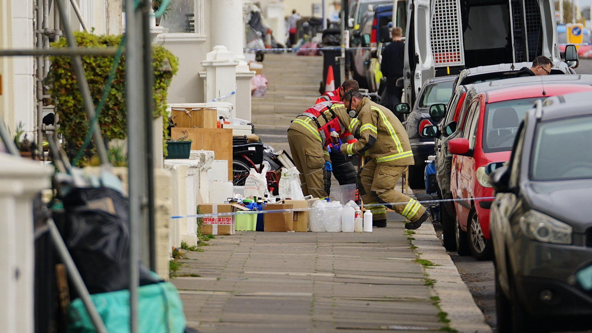 Members of the emergency services remove chemicals from a property and place them on the pavement before they get destroyed.