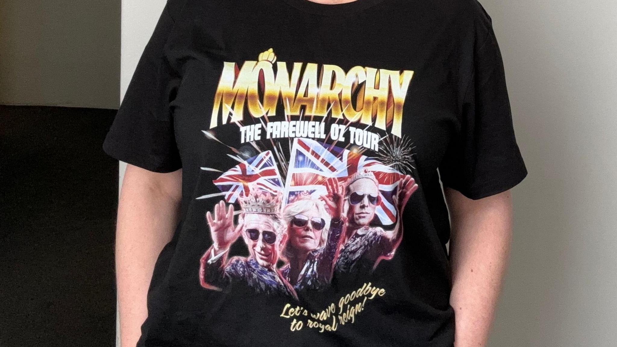 A woman wearing the Australian Republican Movement merch. It's a t-shirt which reads "Monarchy the farewell Oz tour" and "Let's wave goodbye to Royal reign!". It features edited photos of King Charles in a crown, Queen Camilla and Prince William. All three are wearing sunglasses.