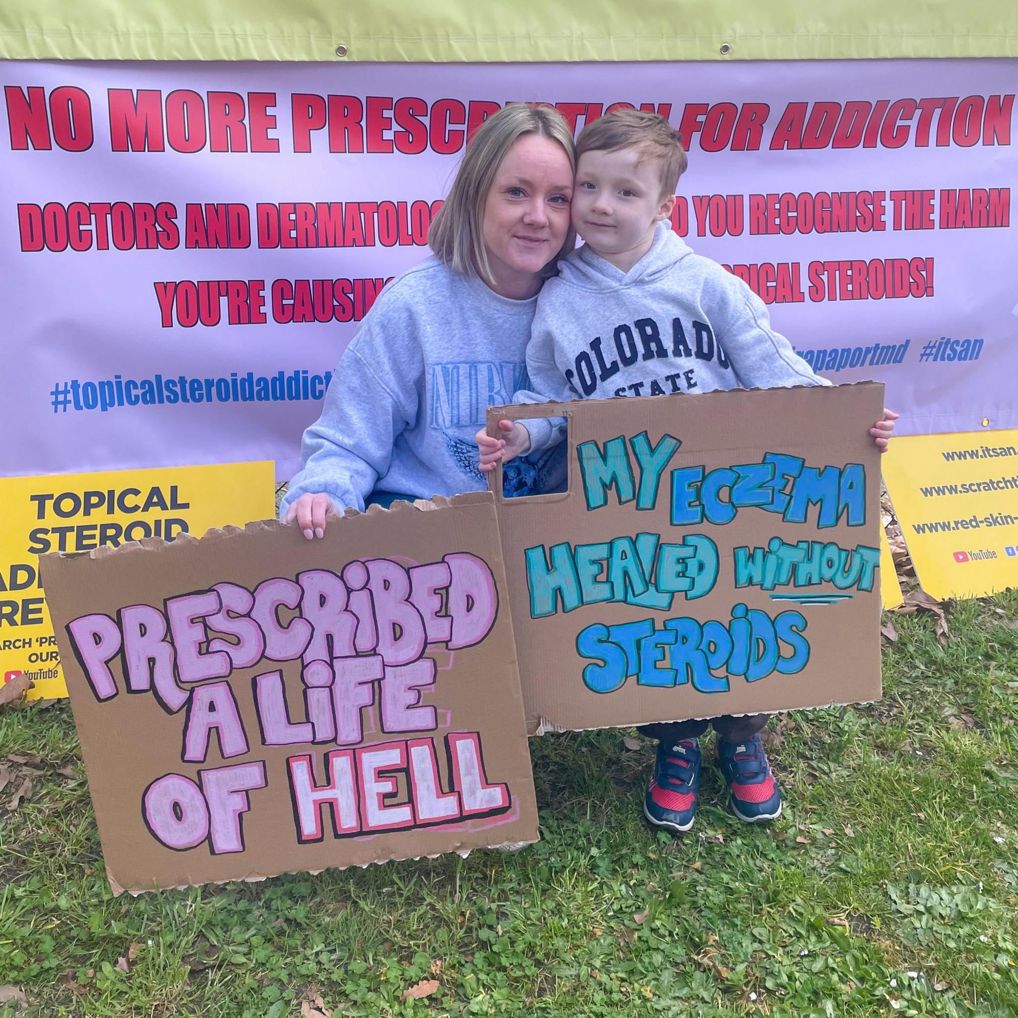 Bethany Norman and her son hold placards at a protest against the use of steroids.