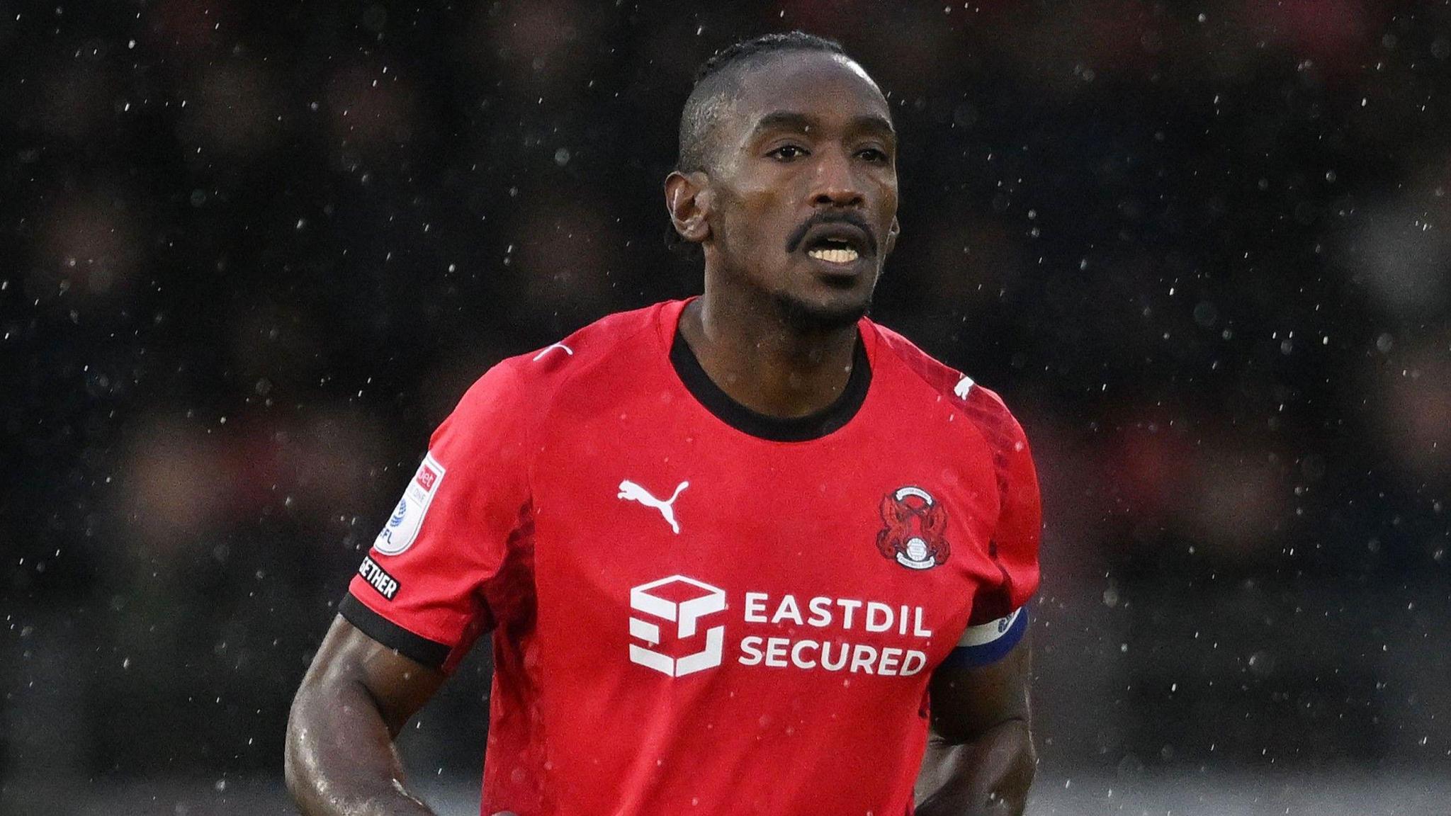 Omar Beckles running in rain in Leyton Orient home kit