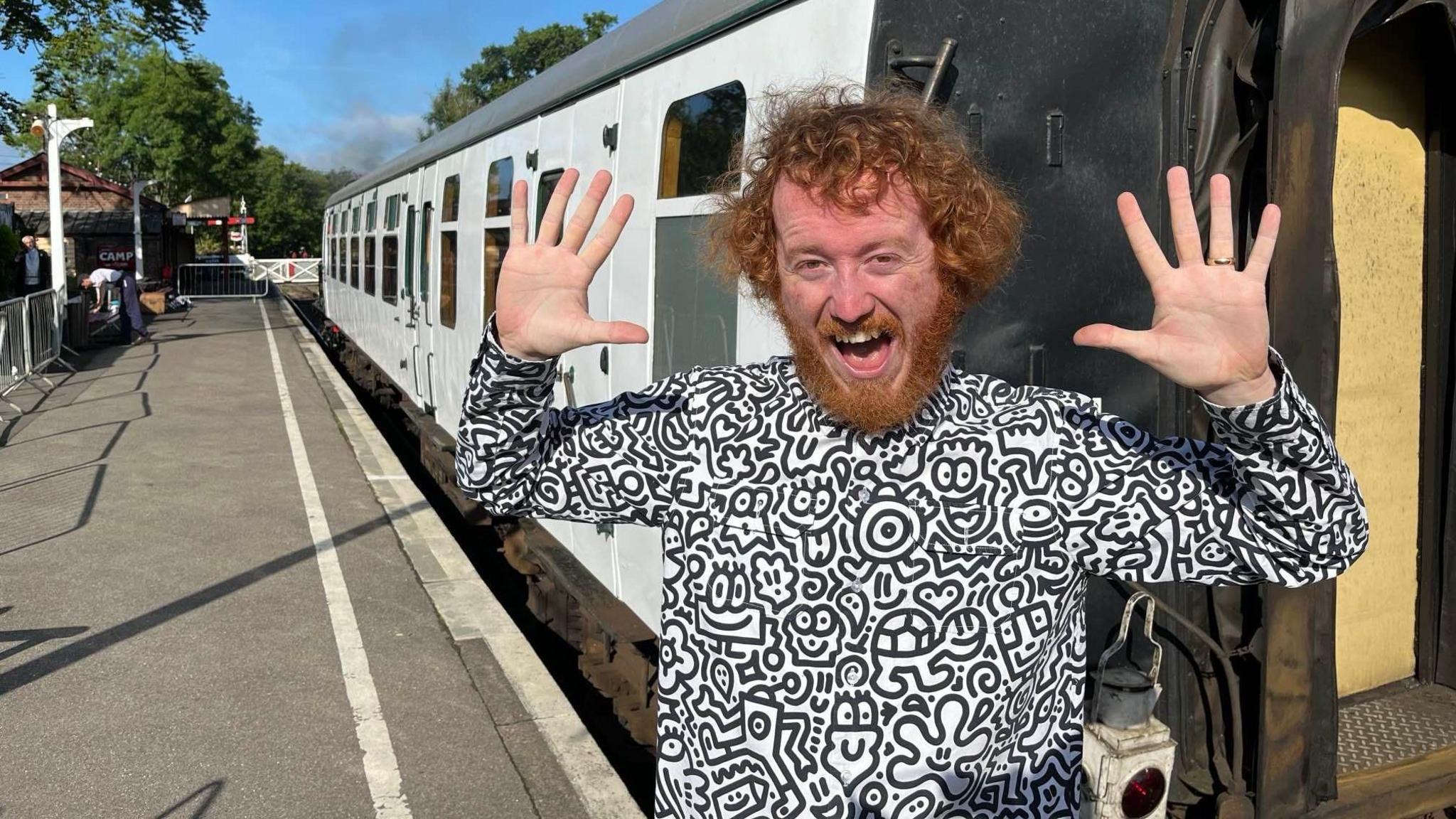 Mr doodle smiling next to train