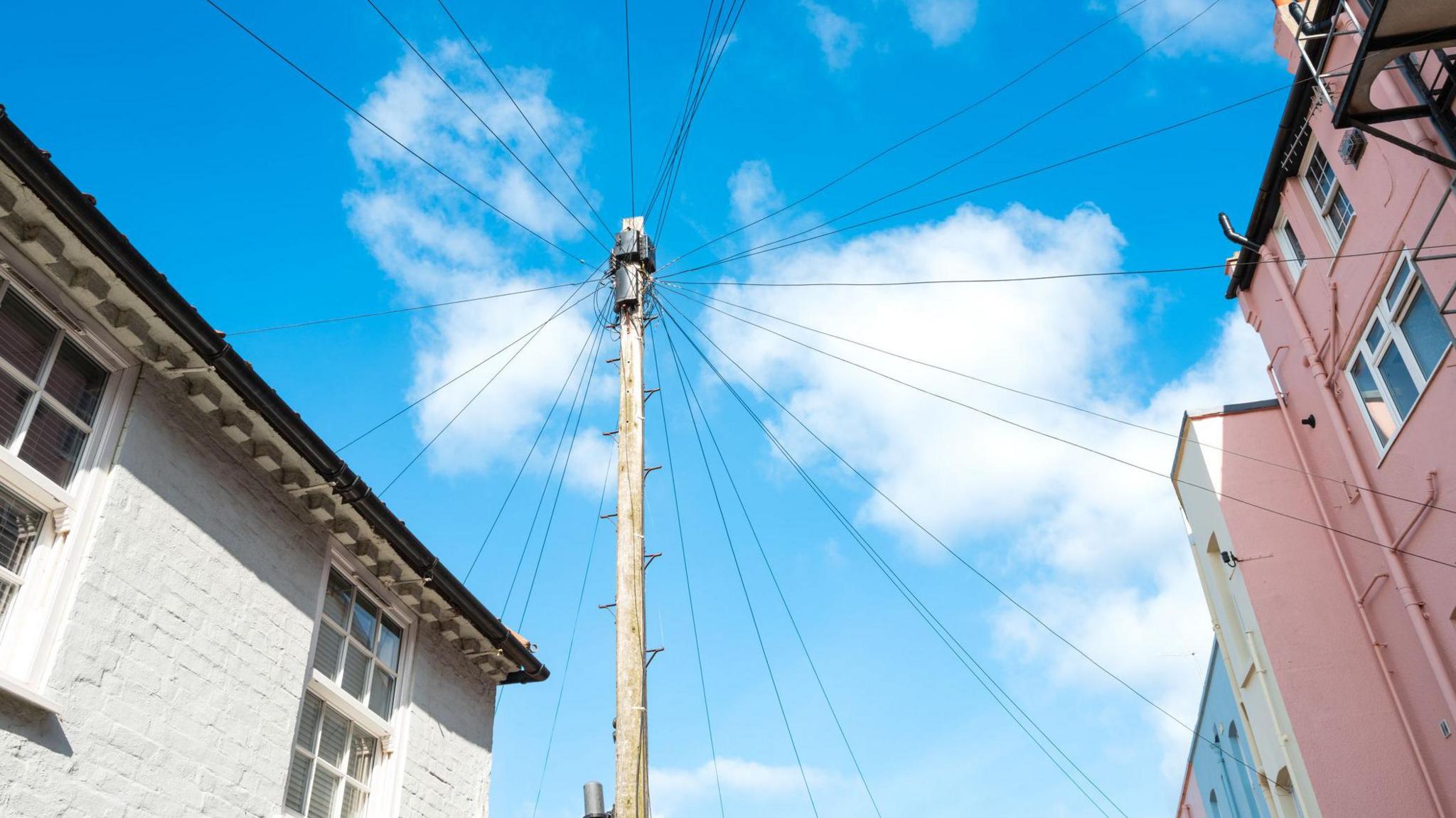Stock image: Telegraph pole in between two buildings.