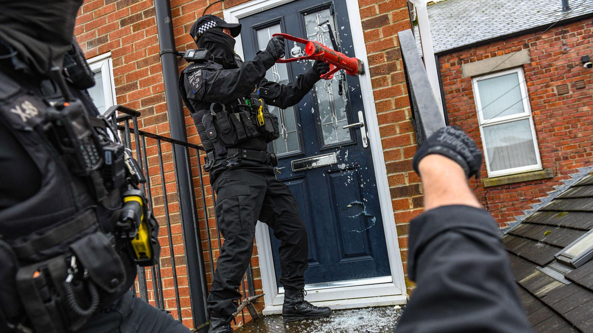 Police officer raiding one of the properties