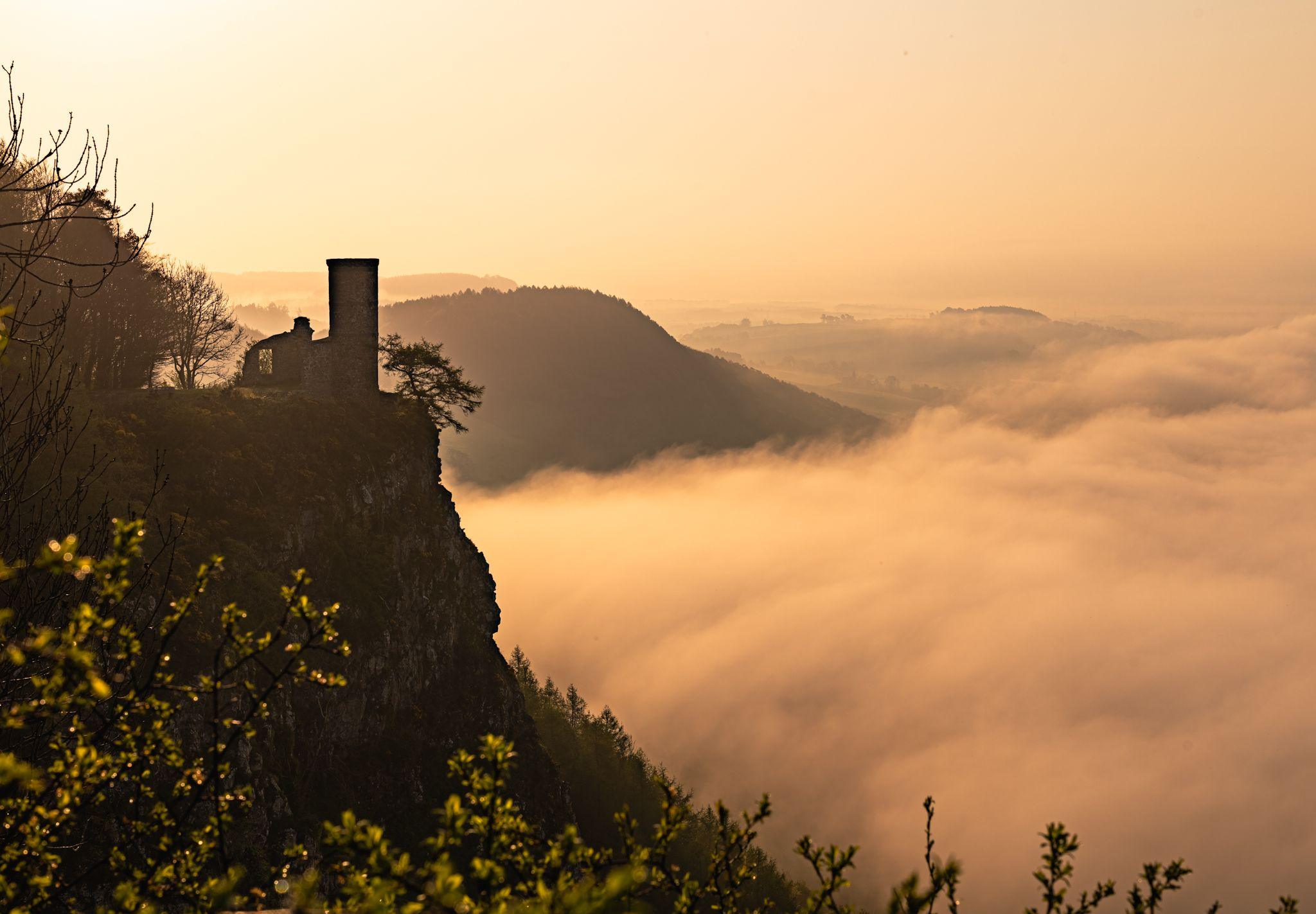 Landscape image of clouds over a hill at sunrise