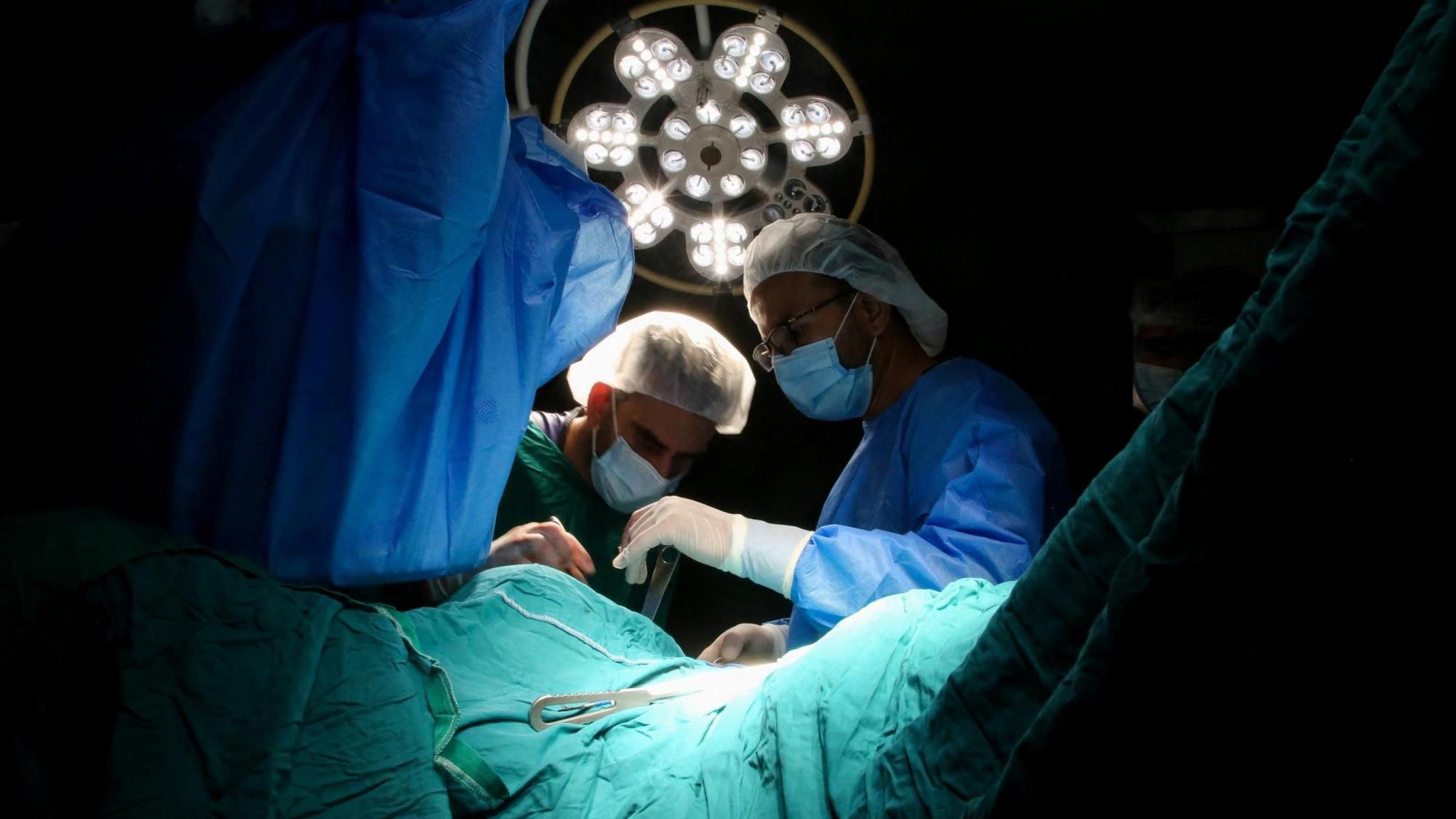 Medical personnel work in an operating room at Nasser hospital, in Khan Younis, southern Gaza, amid a critical fuel shortage (9 July 2025)