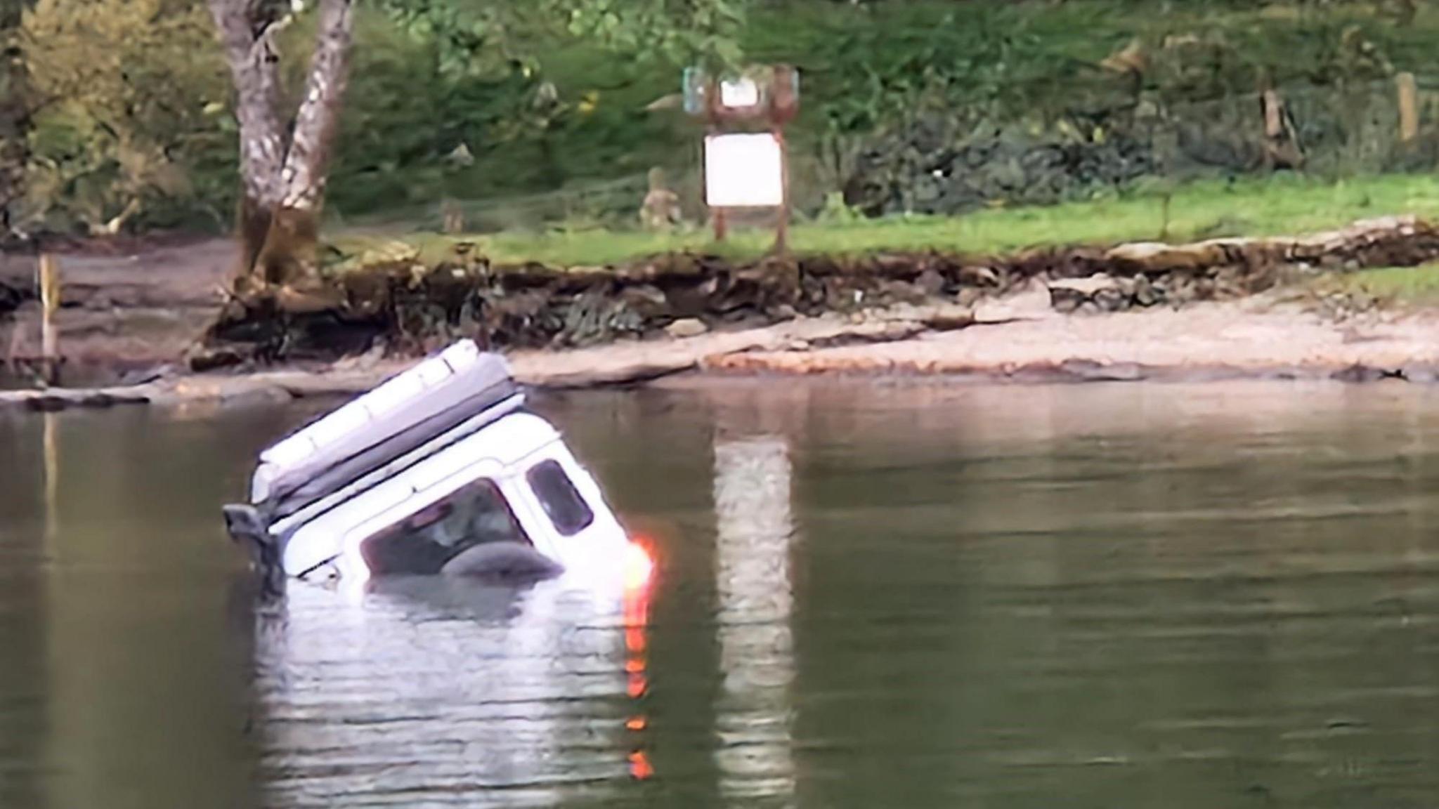 The Land Rover seen from the back before a tractor helped pull it out of Windermere.