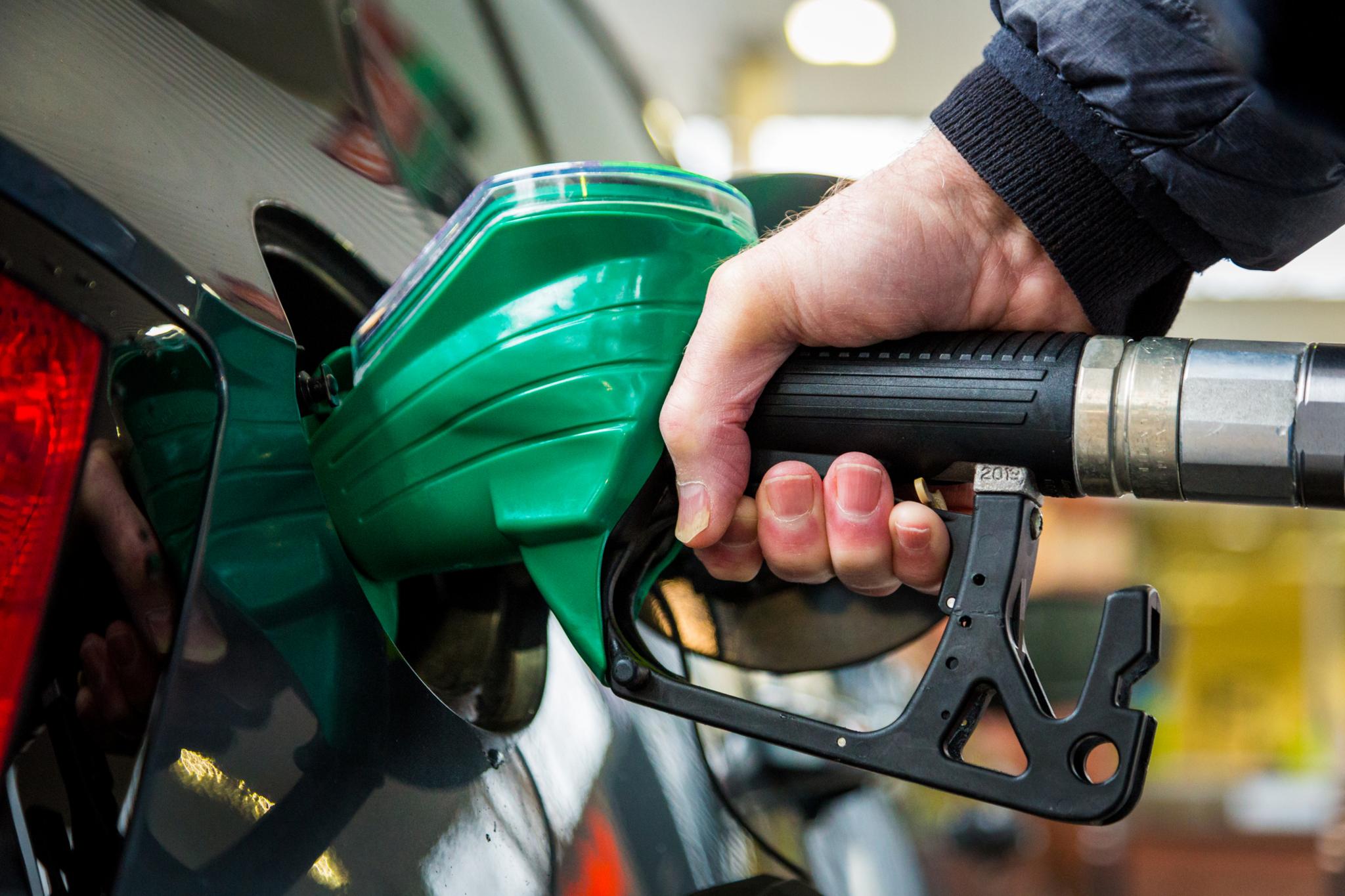 A person putting fuel into their car using a petrol pump