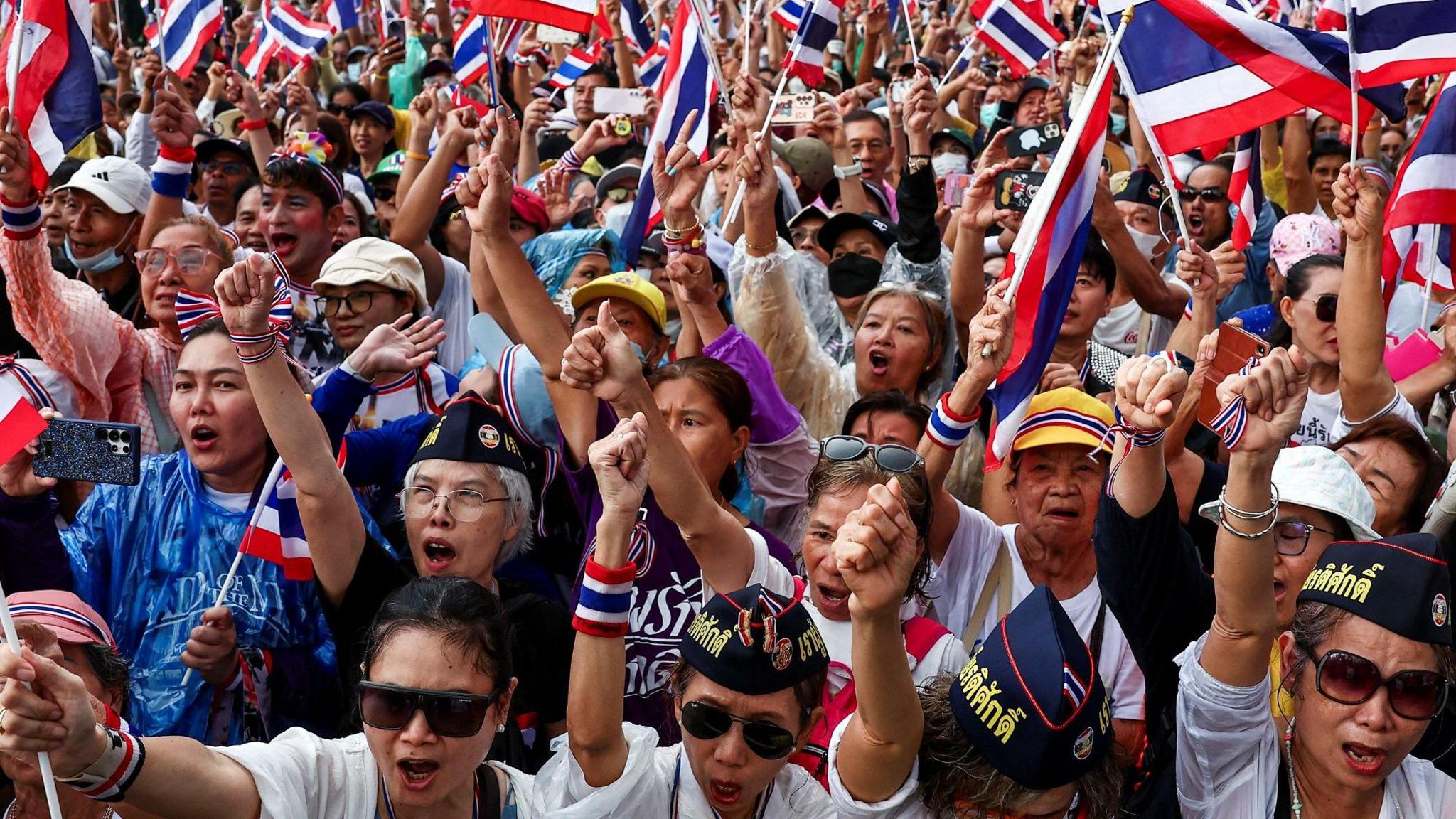Anti-government protesters gather at the Victory Monument with Thai flags. The entire image is filled with them.