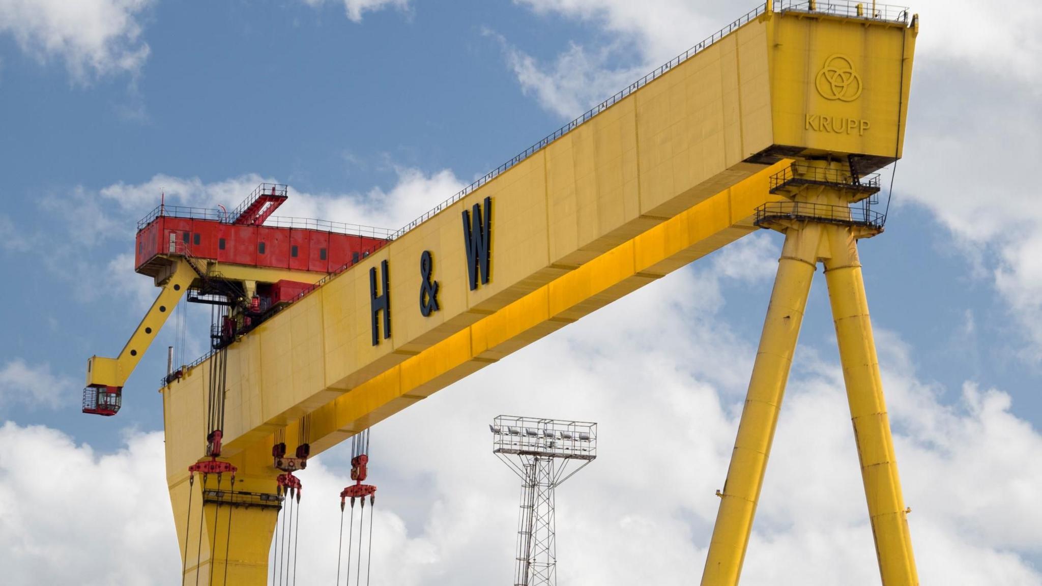 One of the Harland and Wolff cranes in Belfast. It is yellow with black 'H&W' letters on it and a red cabin on top. 