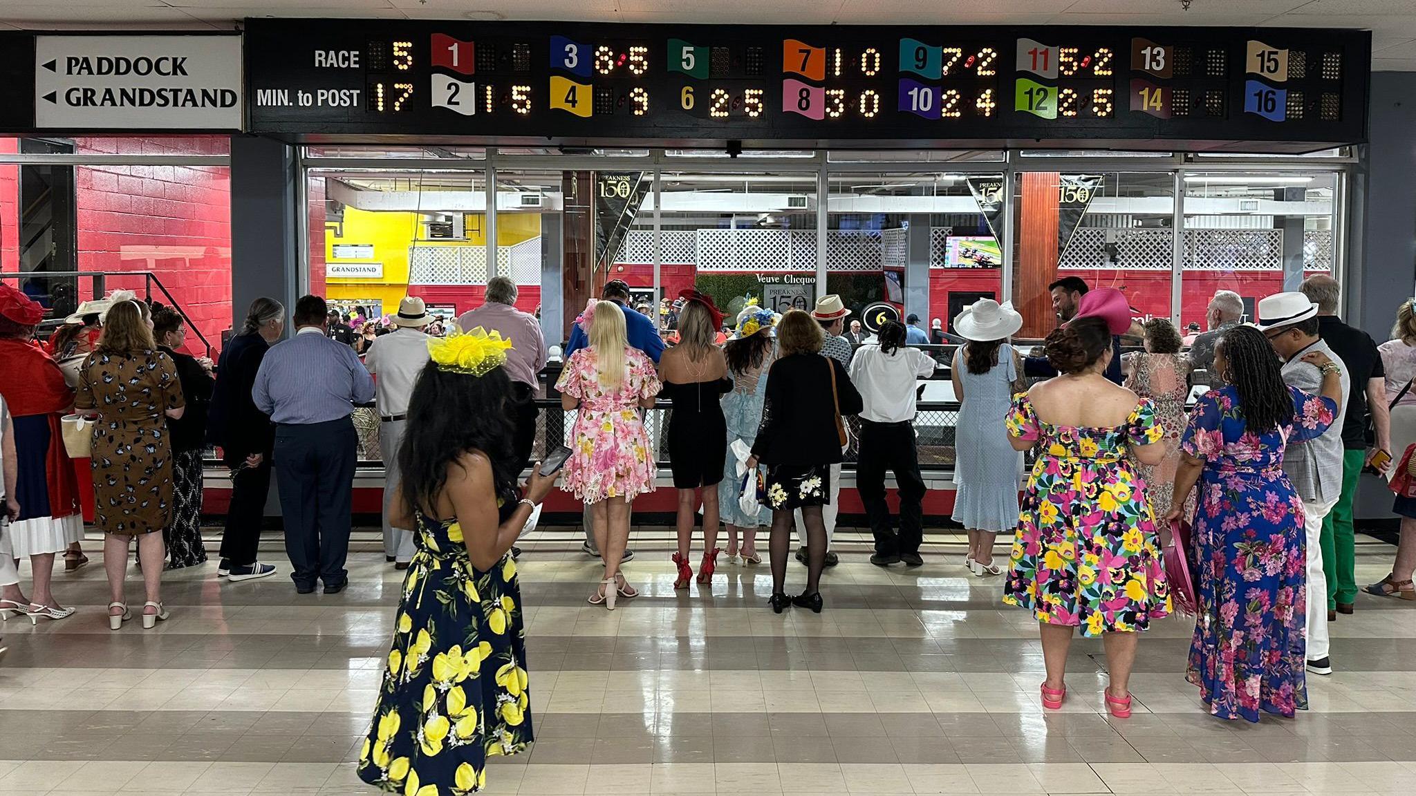 Race fans look at the horses before they're brought onto the field at Pimlico