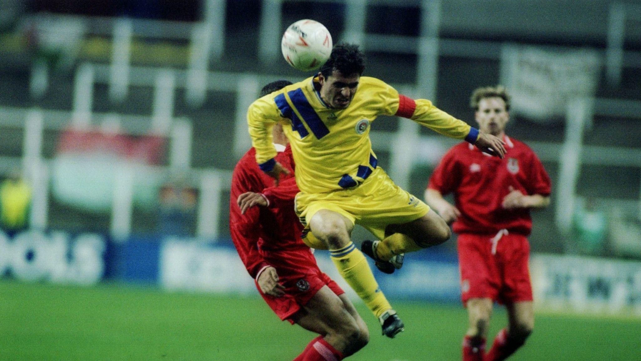 Gheorghe Hagi heads the ball as Paul Bodin looks on