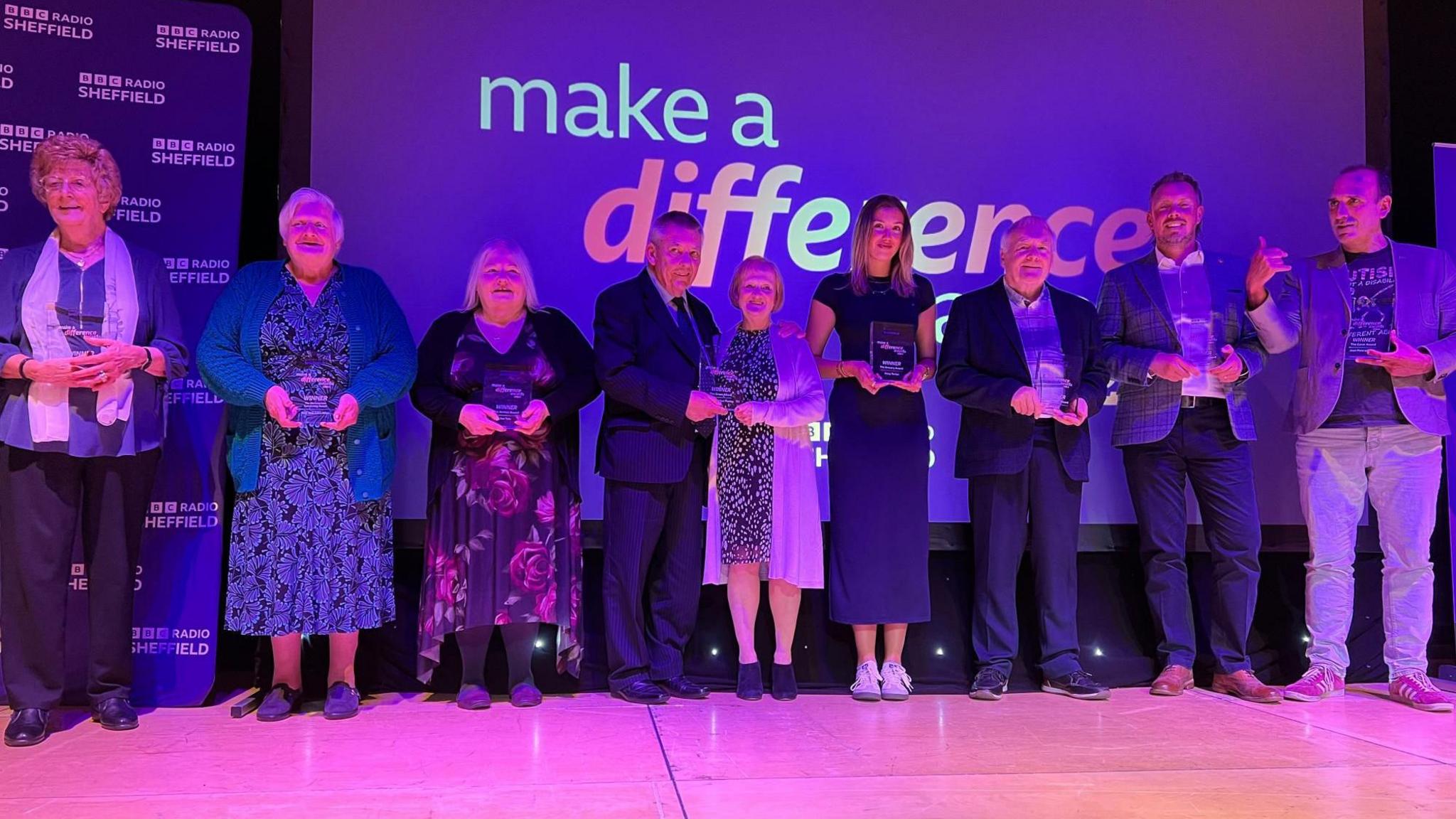 People standing holding awards