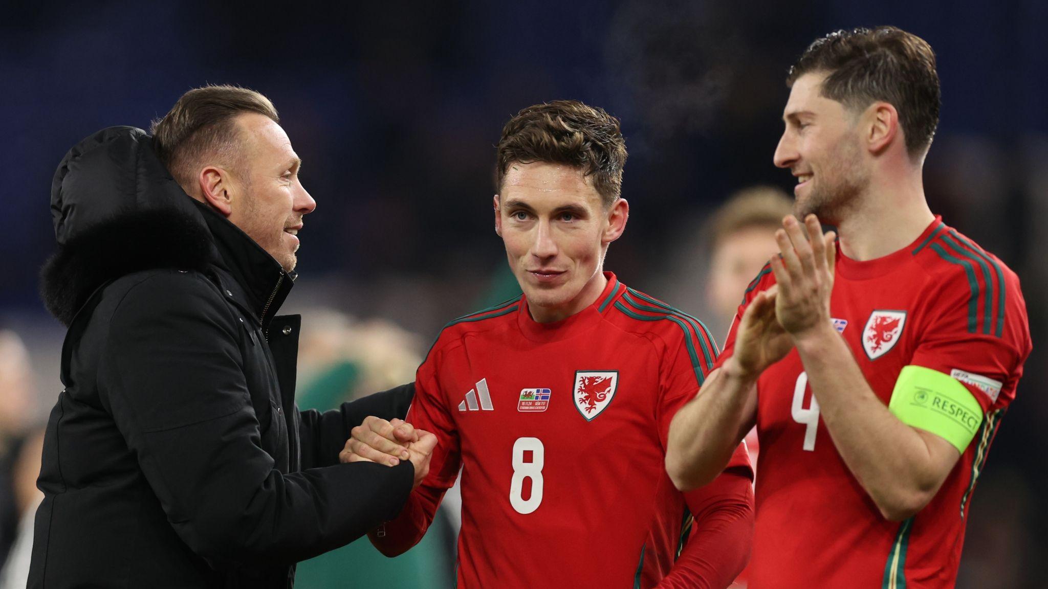 Craig Bellamy (left) congratulates Harry WIlson while a smiling Wales captain Ben Davies applauds