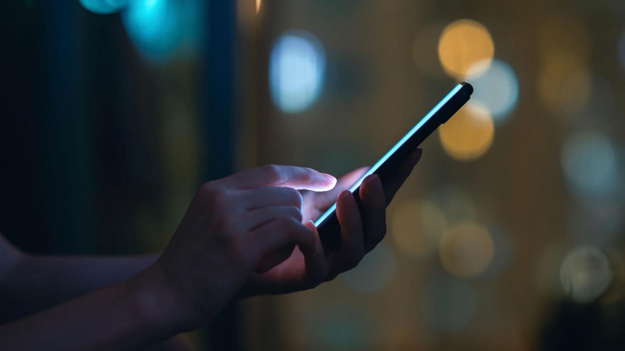 A close up of a person's hands holding a phone. 