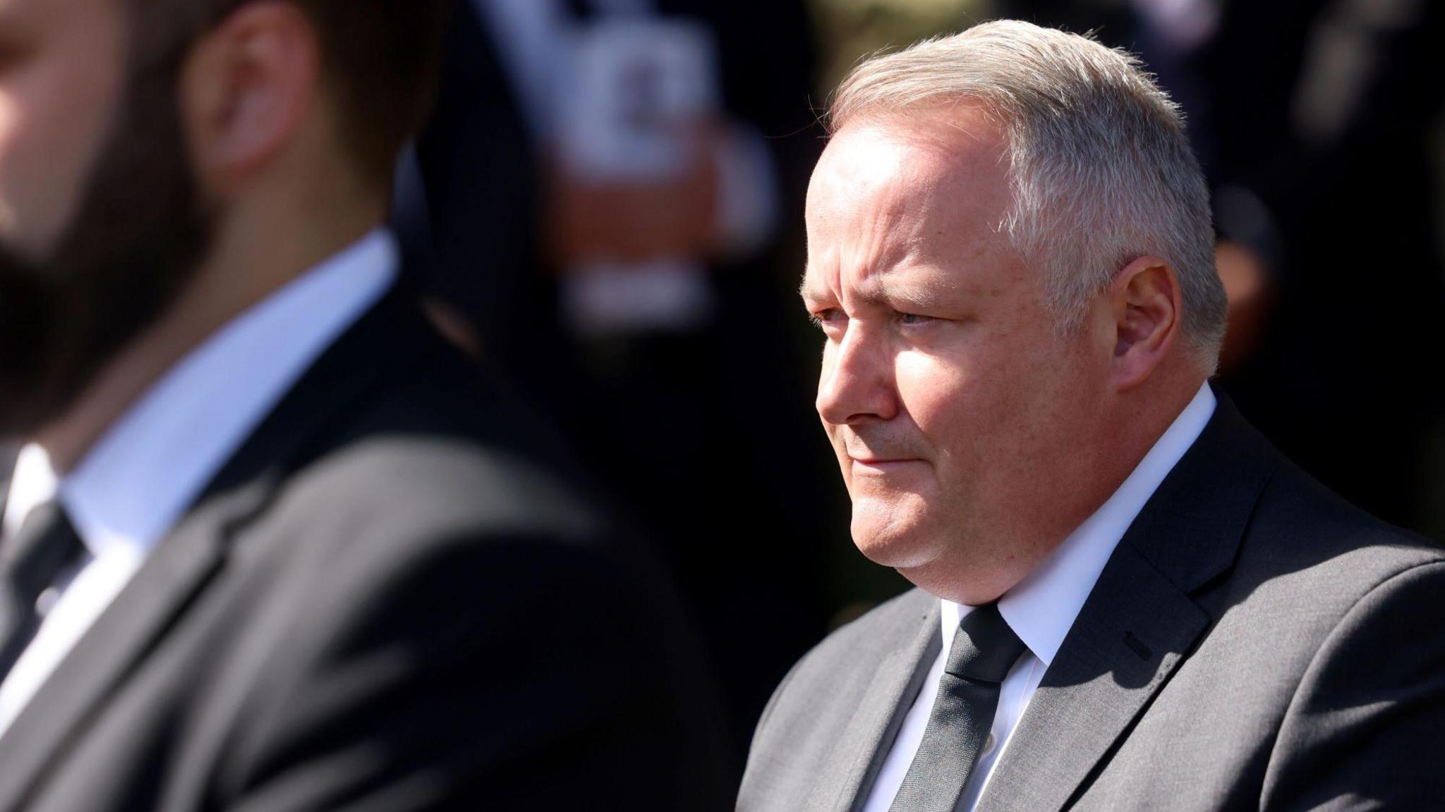 Darren Millar stood to the right of the photograph, wearing a black suit, white shirt and black tie.