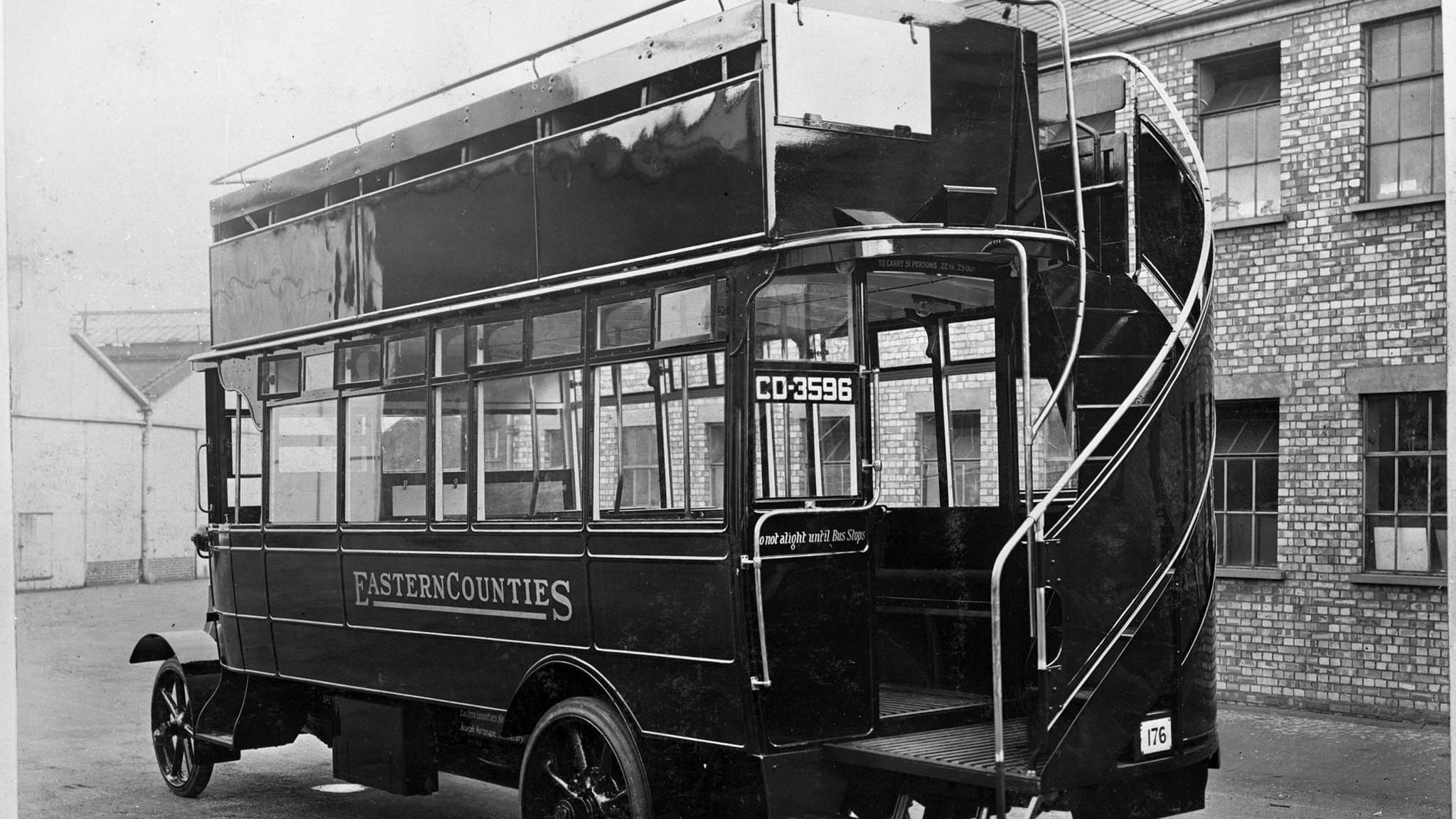 A black and white photo of an Eastern Counties bus in 1922. It shows an open top bus with stairs leading up to the top floor.