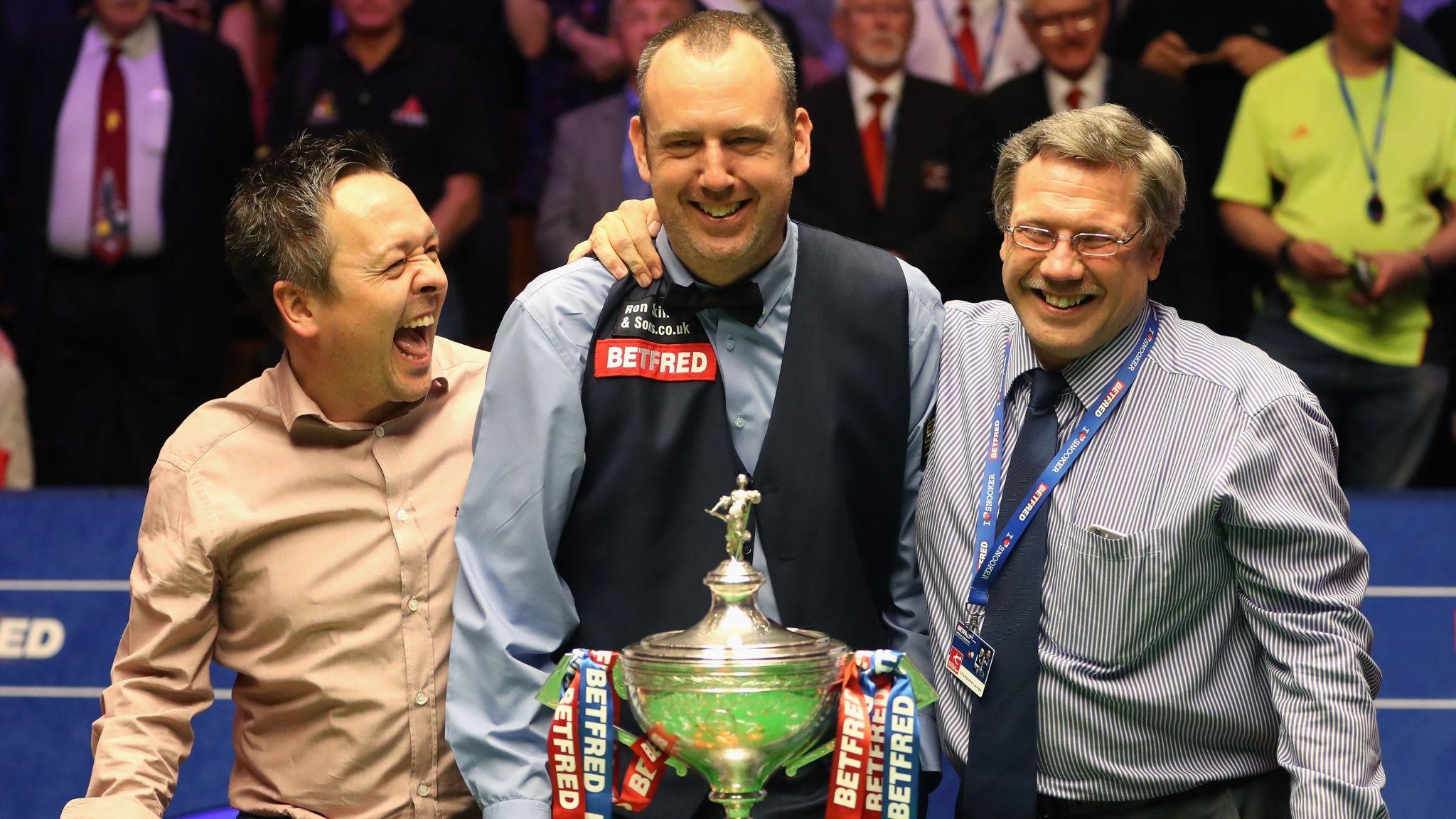 Lee Walker (left) and Stephen Feeney (right) pose for a picture while celebrating with Mark Williams and his trophy after he won the 2108 World Snooker Championship