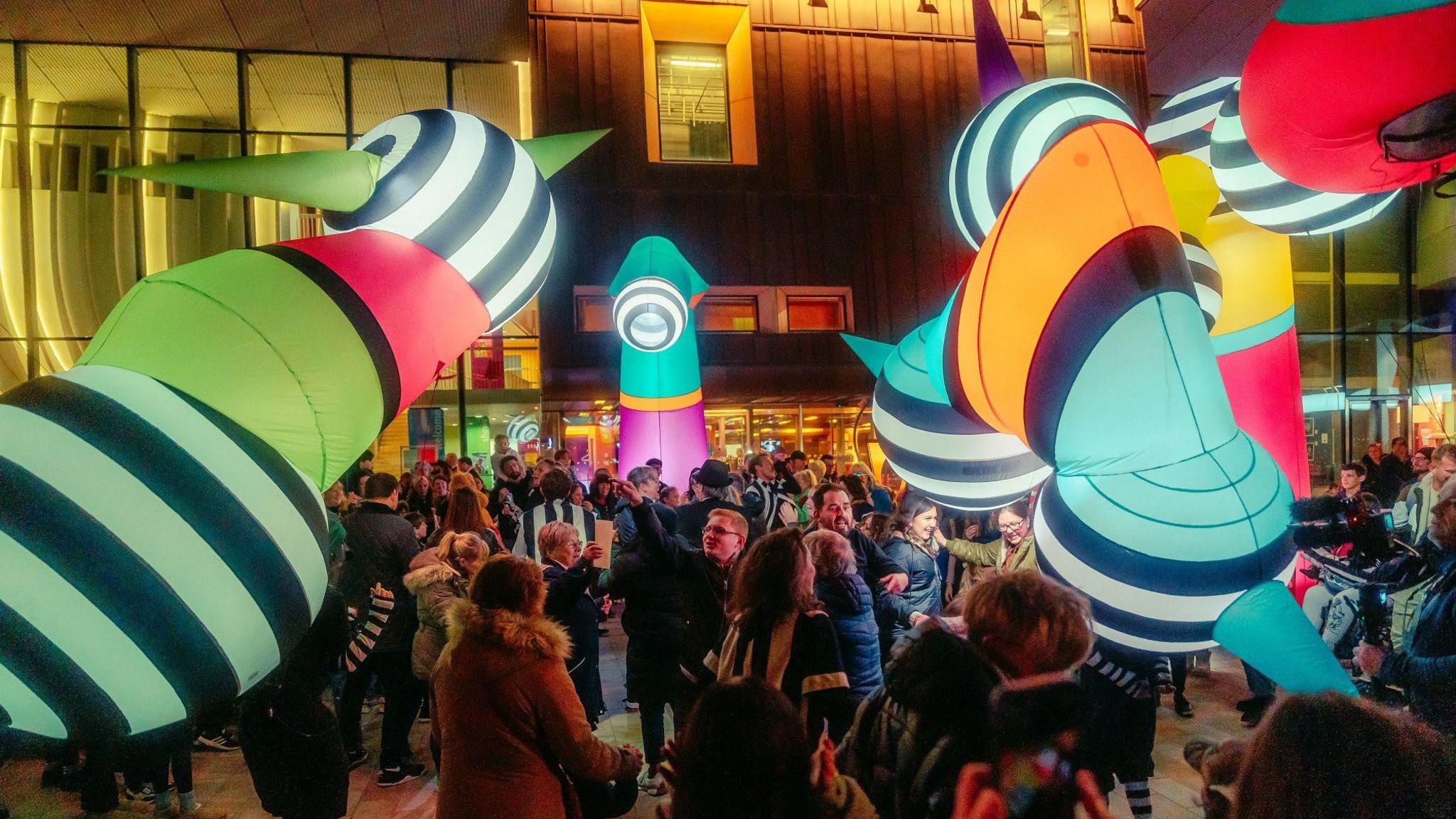 Giant colourful puppets interacting with people