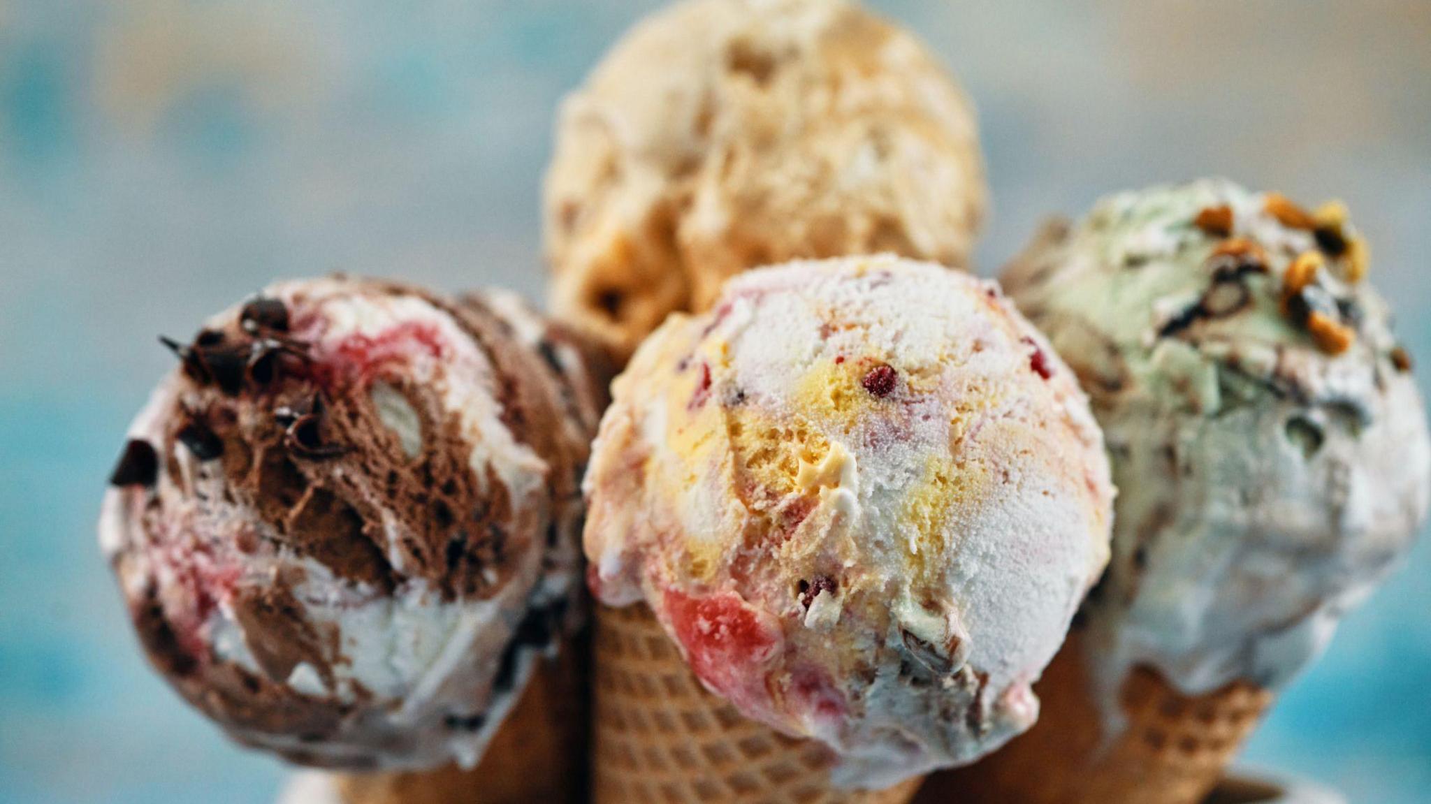 A selection of ice cream cones with different flavour toppings