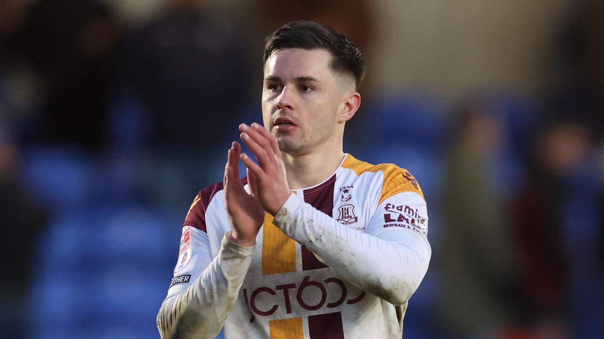 Callum Johnson about to clap his hands together after an away match with Bradford 